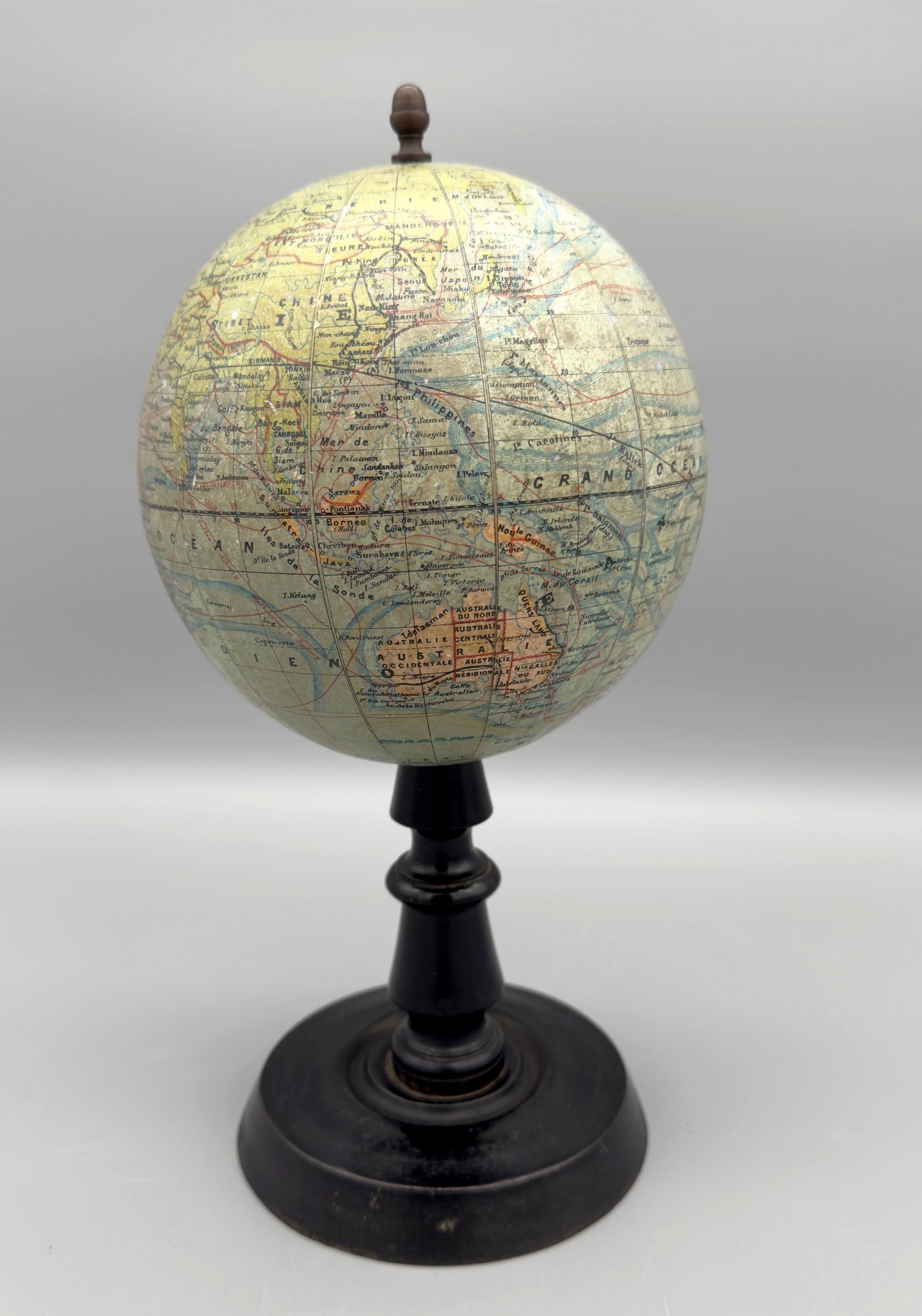 Small terrestrial globe on a blackened and waxed turned wood stand. The globe is made of polychrome printed paper mounted on plasterboard.
It bears the inscription “globe terrestre dressé par J Forest géographe. On sale in Paris, Maison Forest, 17