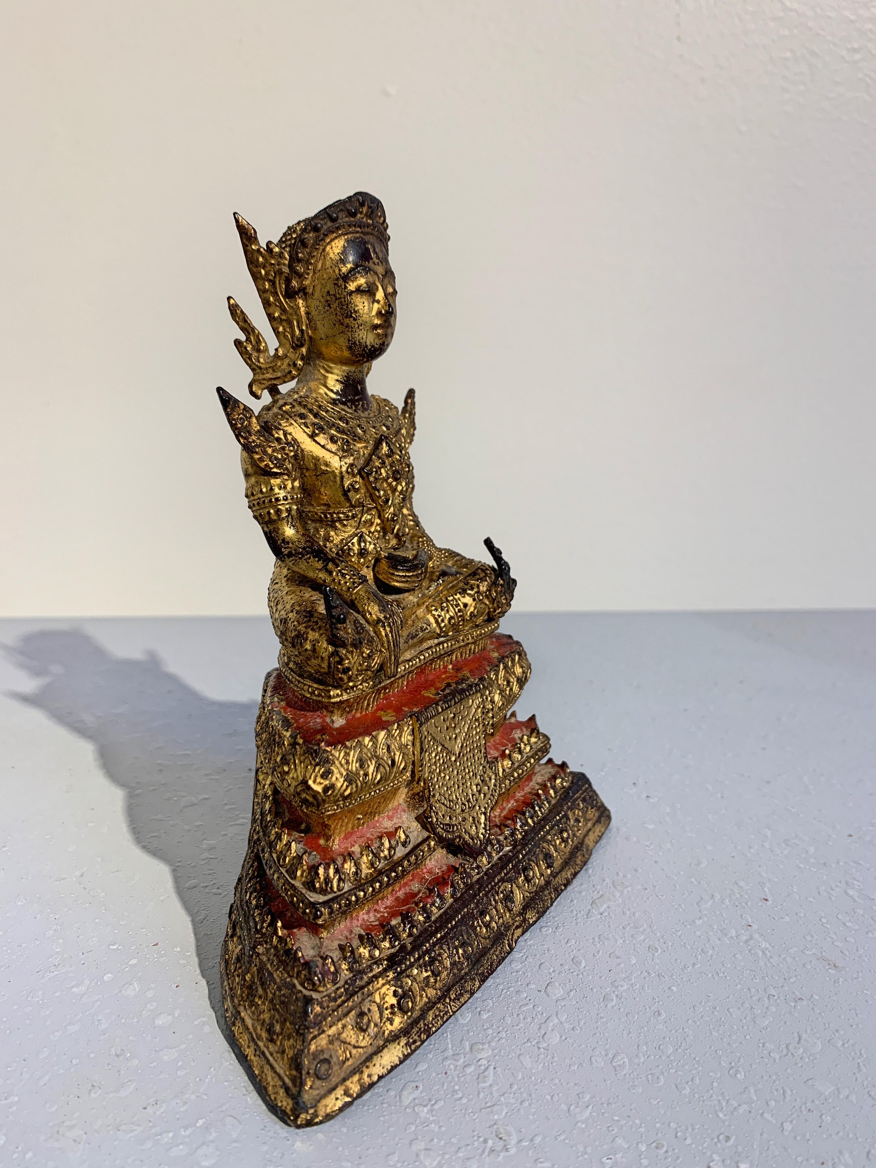 A small and very finely cast, lacquered and gilt bronze Thai Buddha dressed in royal attire, Rattanakosin Period (Rama III), Thailand, mid-19th century. 

Somewhat unusual in its iconography, this figure depicts the Bodhisattva Maitreya, the