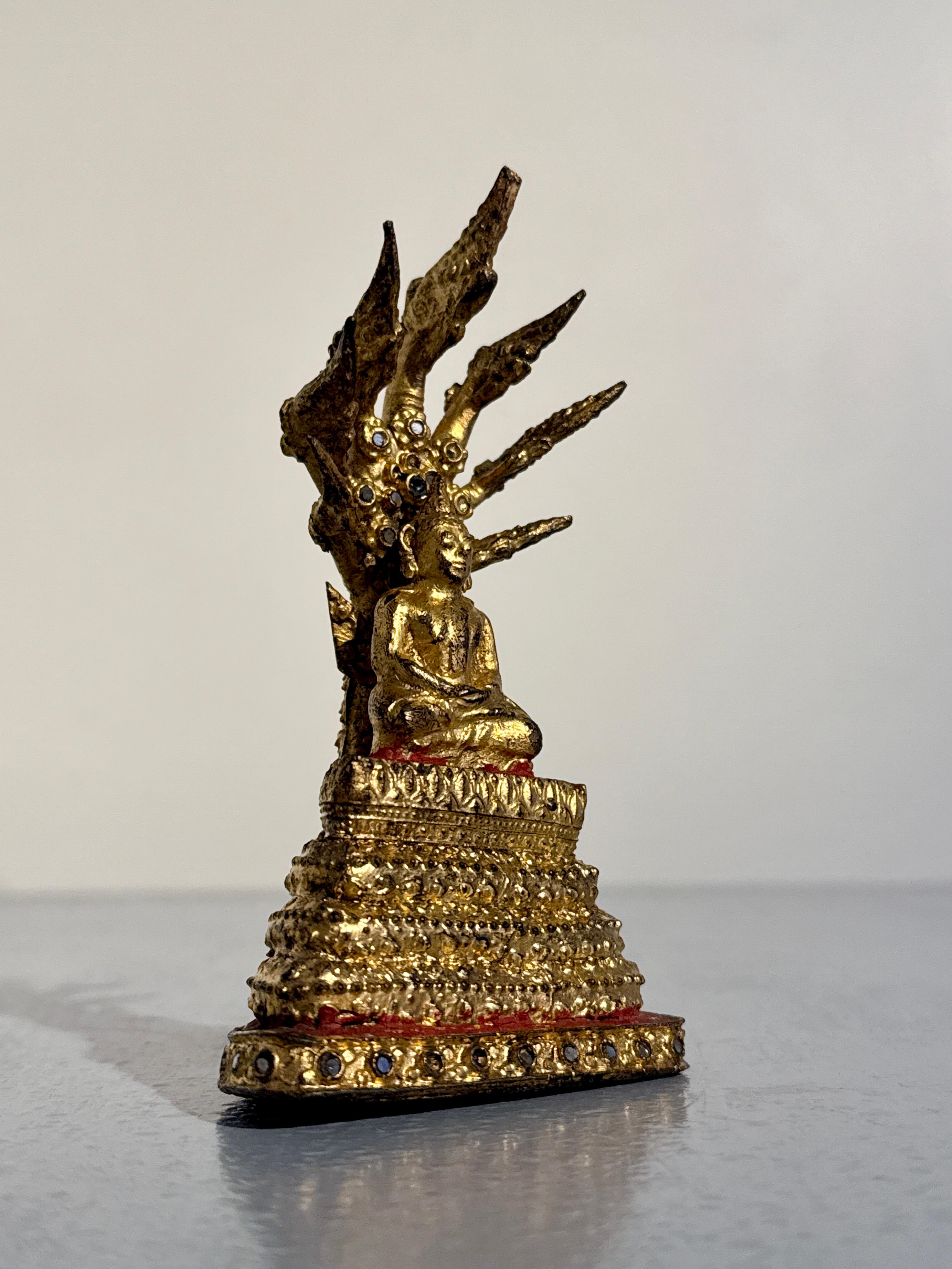 A darling and charming small Thai lacquered and gilt bronze figure of the Buddha Sheltered by a Naga, Buddha Muchalinda, Rattanakosin Period, circa 1900, Thailand.

The small statute depicts the Buddha seated upon a lotus pedestal in meditation upon