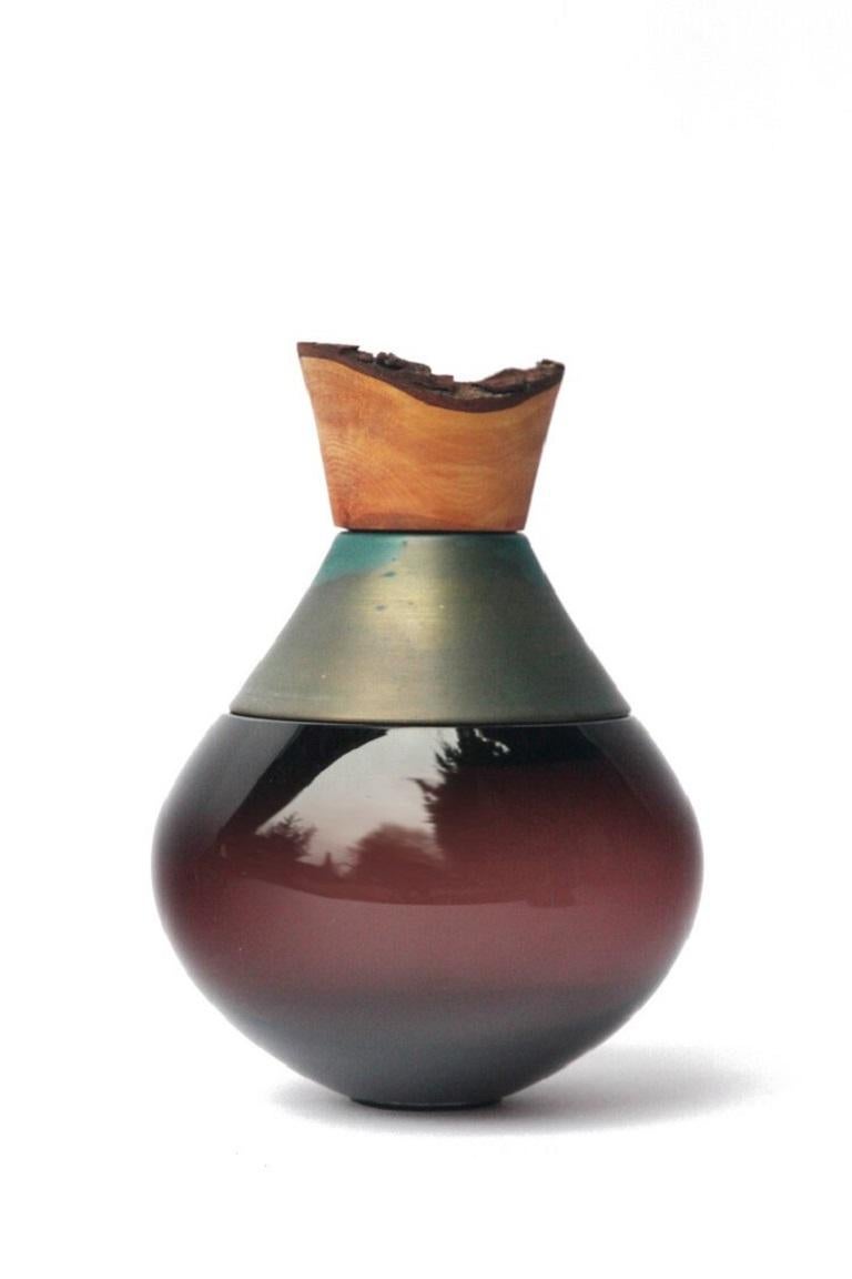 Small topaz and copper patina India vessel II, Pia Wüstenberg
Dimensions: D 18 x H 25
Materials: glass, wood, copper patina
Available in other metals: brass, copper, copper patina, rust

Handmade in Europe, by individual craftsmen: handblown