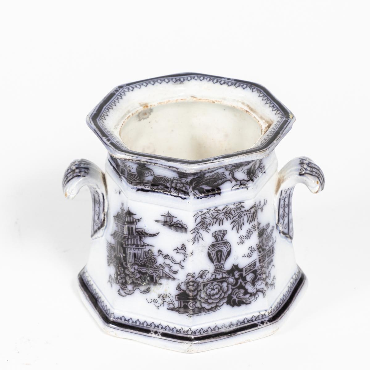 Small Victorian transfer-ware pot with black ink and beveled lid. The Chinoiserie motif depicts a cascade of temples, urns, and flowers. Would serve equally well for both practical and decorative use. 

Produced by the Staffordshire pottery W. Adams