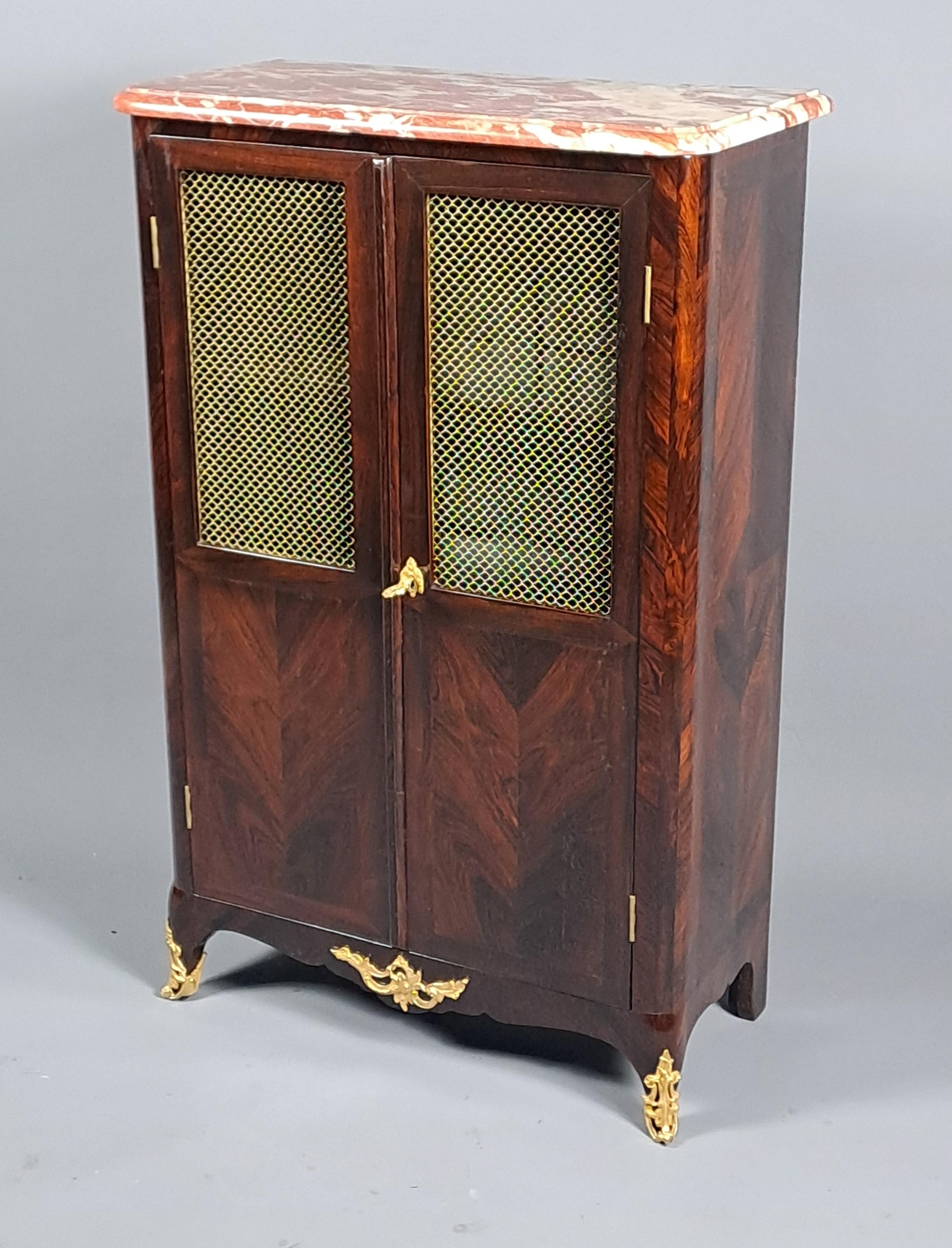 Exceptional bookcase with support height made of brown Rio rosewood veneer and topped with a red Languedoc marble top, opening two leaves on the front and presenting a beautiful ornamentation of finely chiseled gilt bronze.   

Stamped RVLC and
