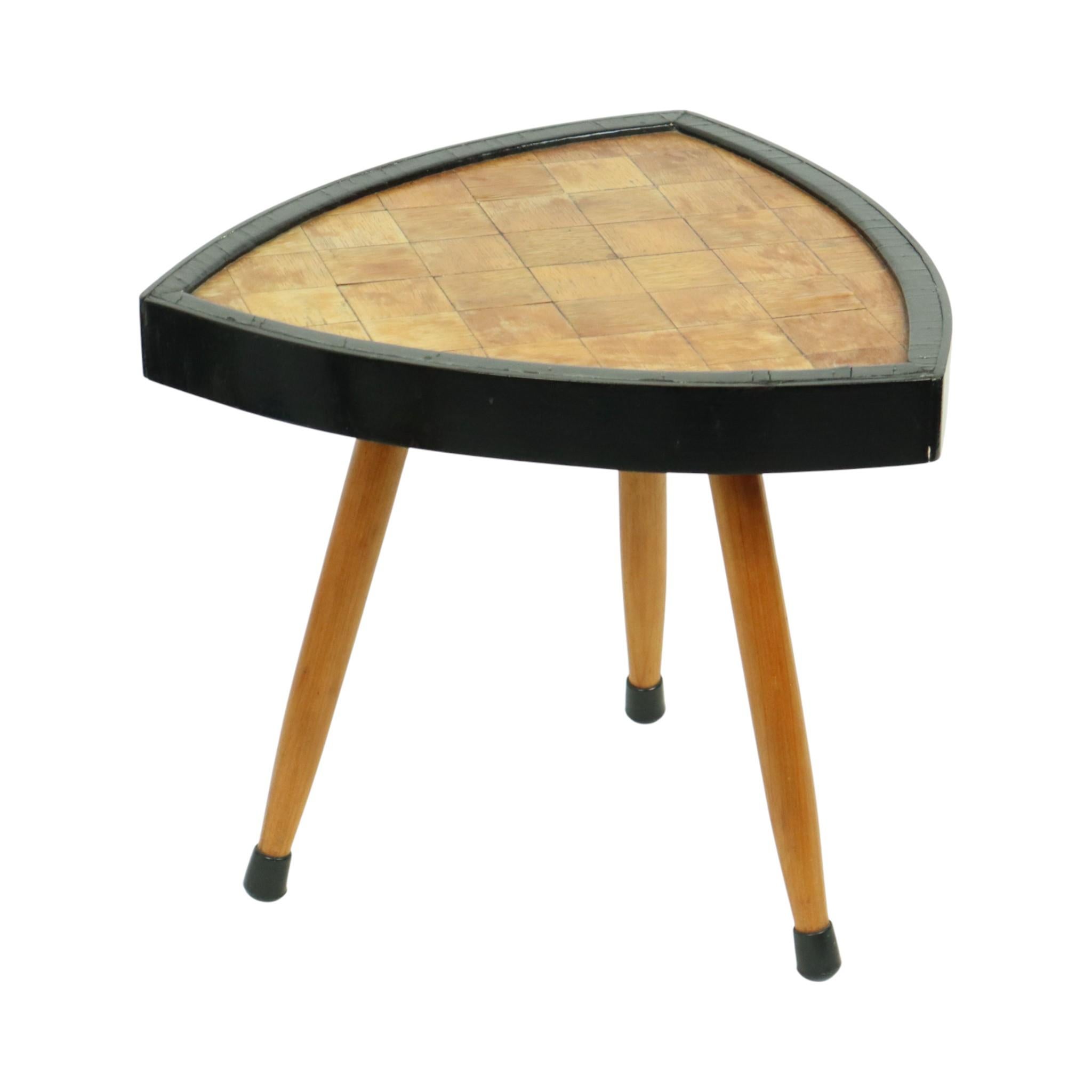 Petite table à plantes triangulaire du milieu du siècle, avec incrustation de parquet et bord en bois laqué noir, reposant sur trois pieds coniques. Cette authentique table à plantes des années 1950 et 1960 est en bon état d'usage.

Cette charmante