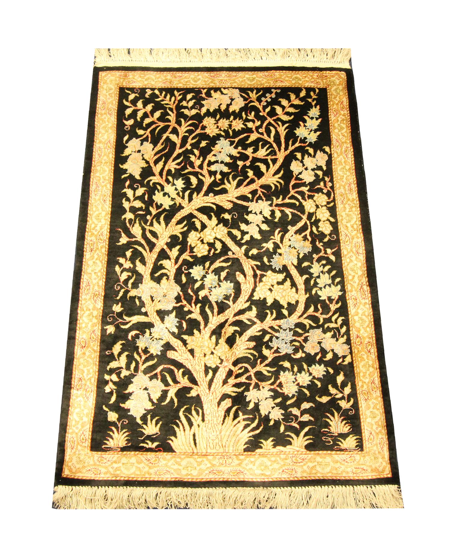 This elegant Silk rug was woven by hand with the finest organic materials. The central design has been woven on a black-brown background with cream and beige accents that make up the magnificent tree design with intricate flowers and leaves woven