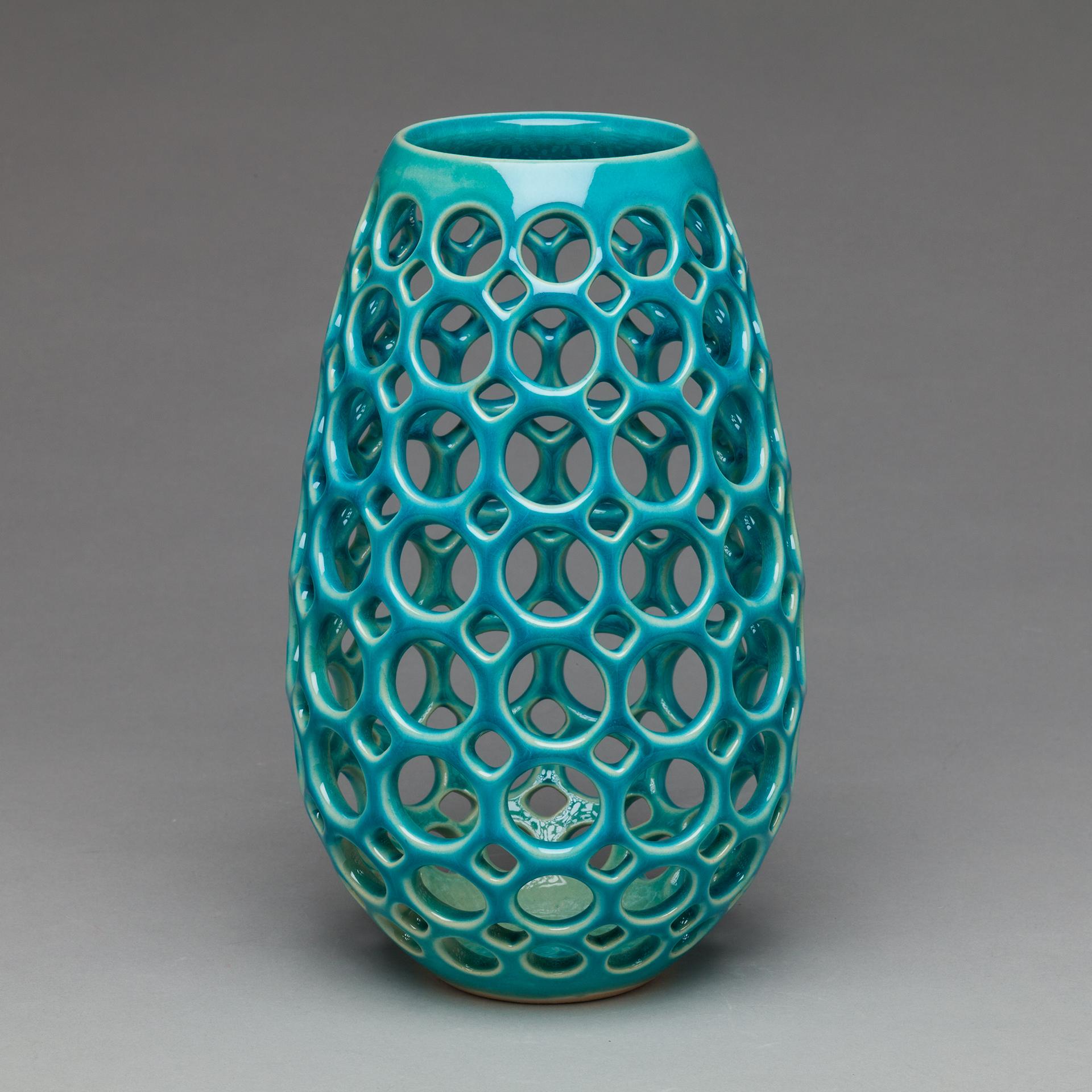 Inspired by Mid-Century Modern design, this piece is wheel thrown and hand pierced stoneware with a satin glaze. Small holes are created when the clay is still wet and then each hole is painstakingly enlarged and smoothed when the clay is bone dry.