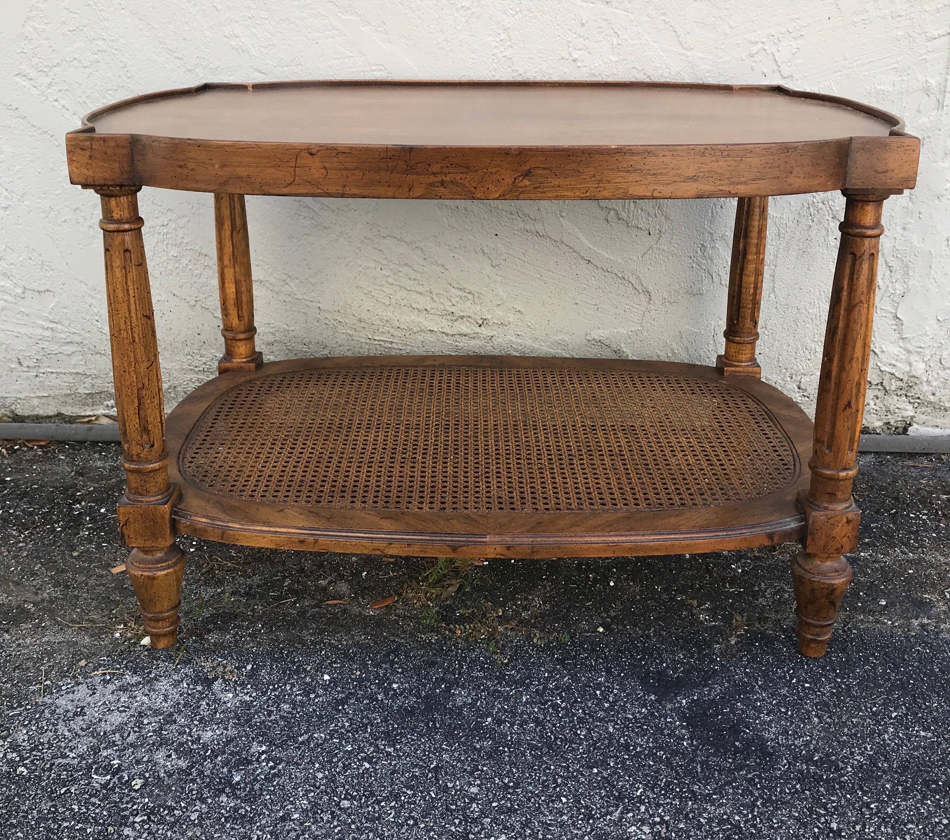 Small two tiered cocktail table with lower cane shelf.