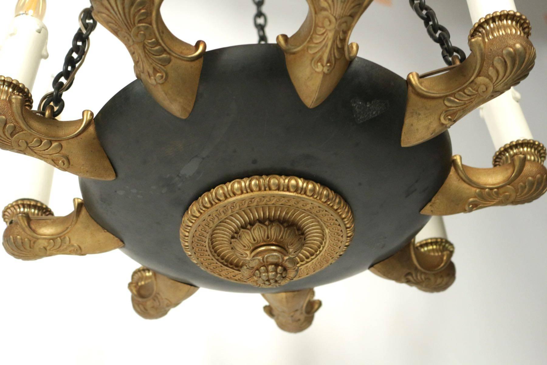 Small unusual Empire chandelier with many arms '9 lights' in the design of an antique oil lamp in gold gilt bronze.
 