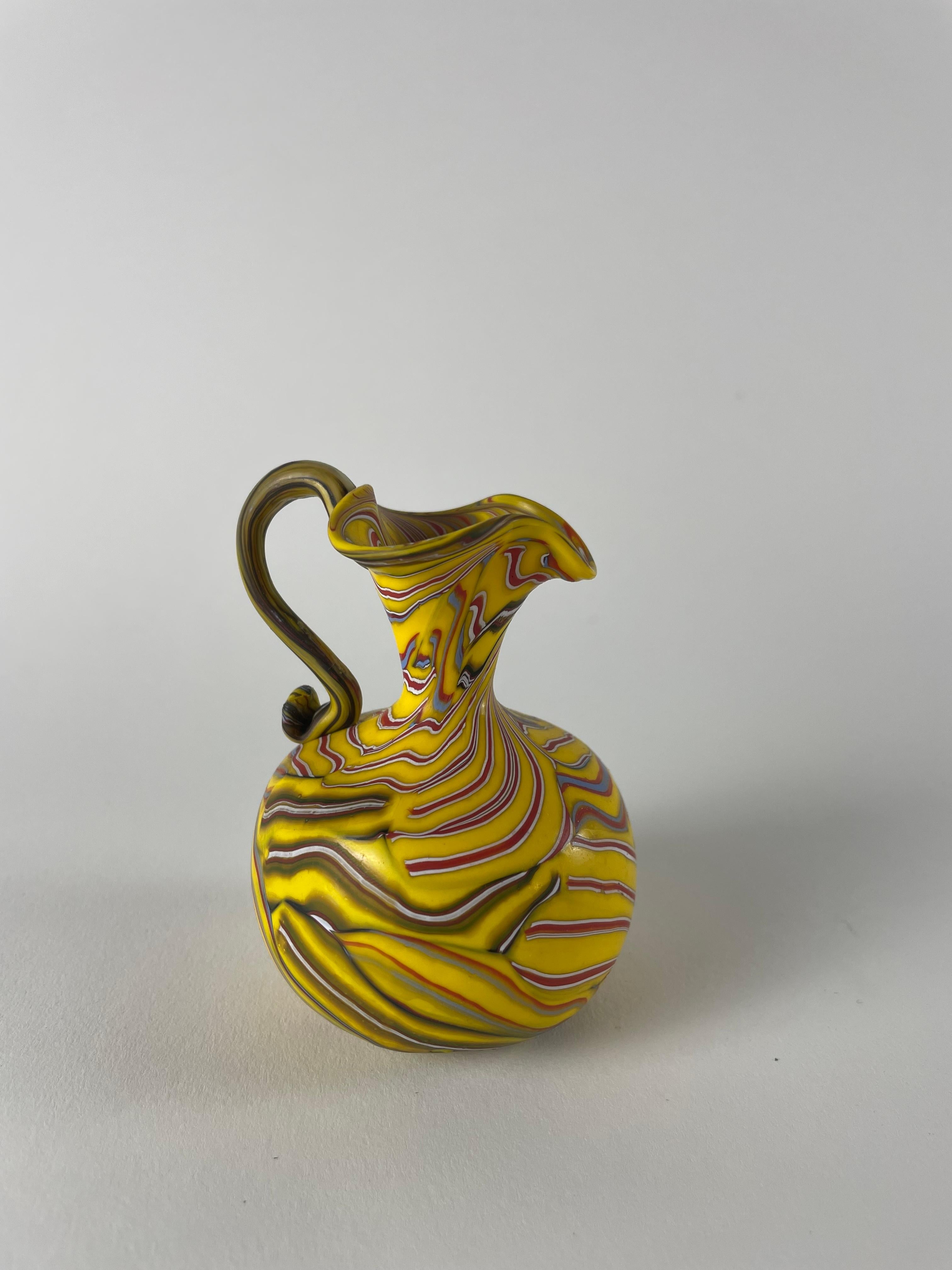 Wir stellen Ihnen den Vaso a cane vor, einen kleinen Schatz, der die unglaubliche Handwerkskunst von Murano verkörpert. Diese exquisite Vase wird in sorgfältiger Handarbeit mit einer einzigartigen Technik hergestellt, bei der kleine Glasstäbe