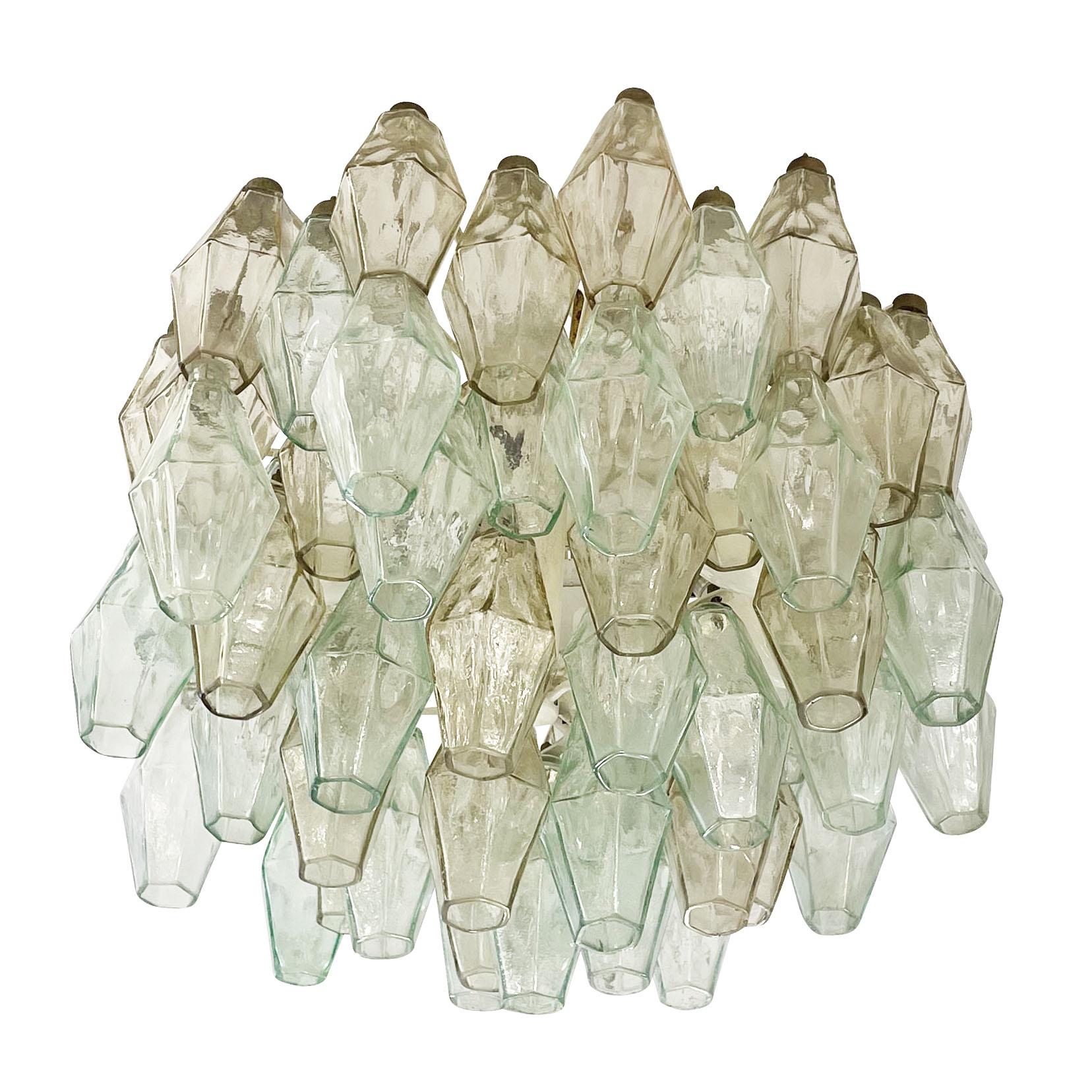 Mid-century chandelier by Venini made with their iconic poliedri Murano glasses. The glasses are a mix of light green ones and amber ones mounted on a white lacquered frame. Ready to hang on a chain.

Condition: 
Excellent vintage condition,