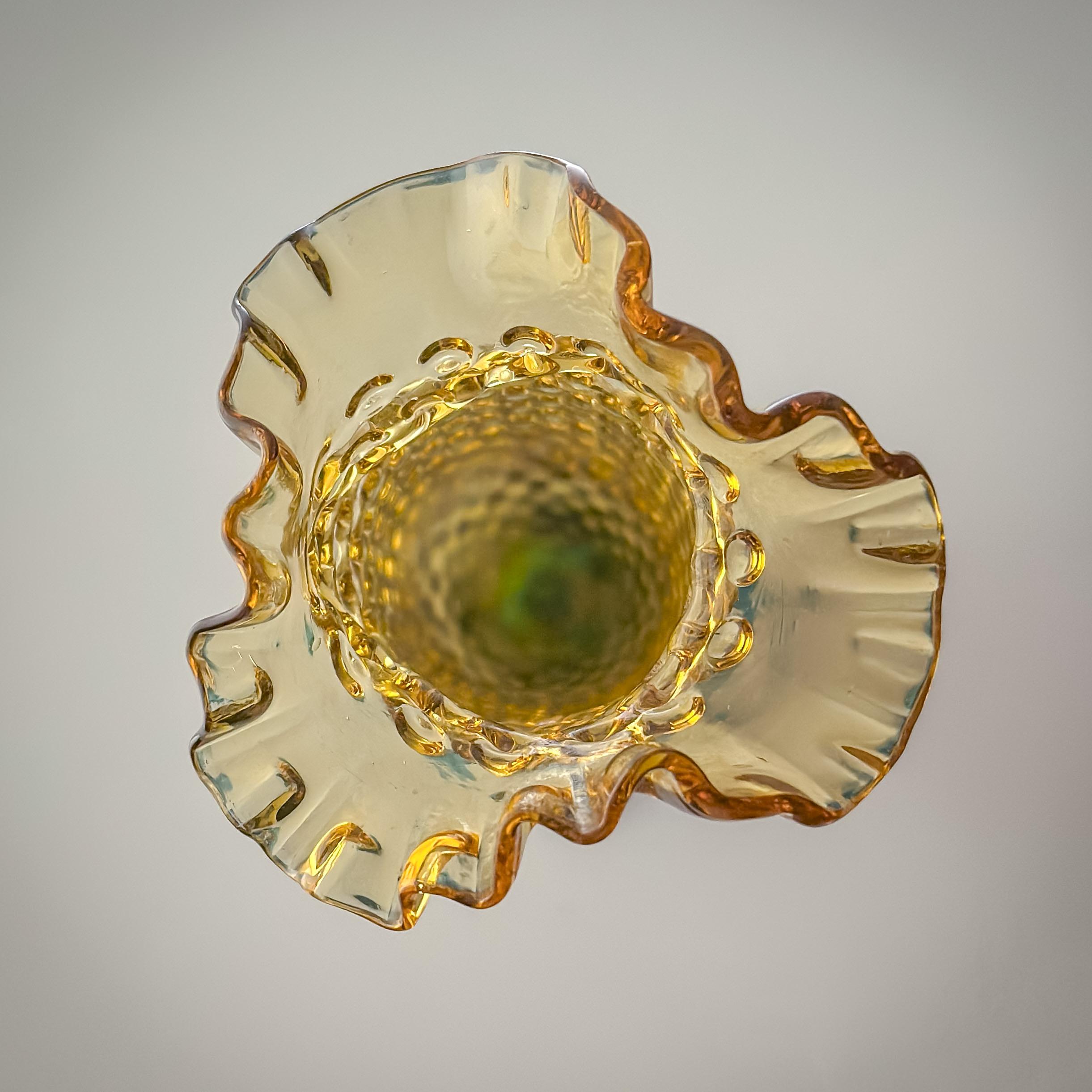 Vaso a chiocciola in vetro ambrato di epoca vittoriana attribuito al vetraio ceco Harrach, circa 1890

Il vaso mostra un'impressionante combinazione di tecniche di lavorazione del vetro: luminosi piedini blu ciano, formati a mano, sostengono il