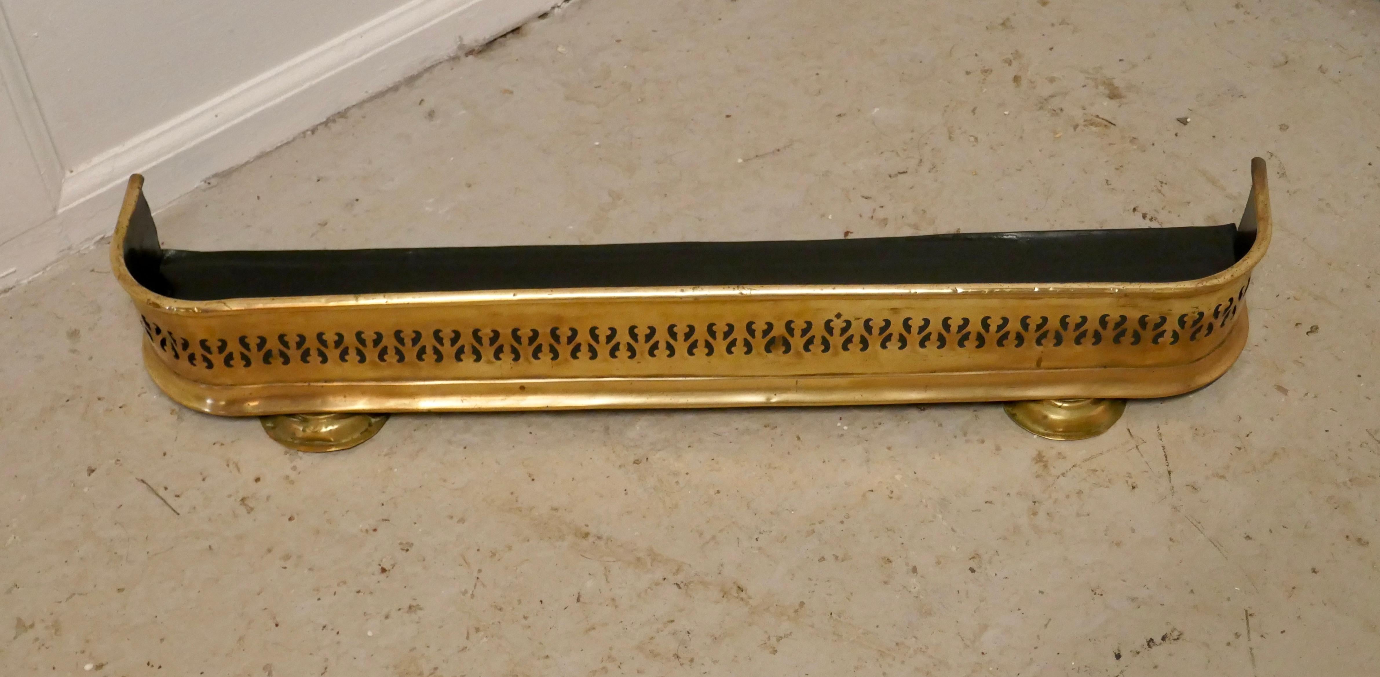 Small Victorian pierced brass fender

This is a Victorian pierced brass fender, it stand on small feet at the front which tilts the fender so that any spilt ash etc. Will roll back into the fire
The fender is in very good condition it is 5” high,