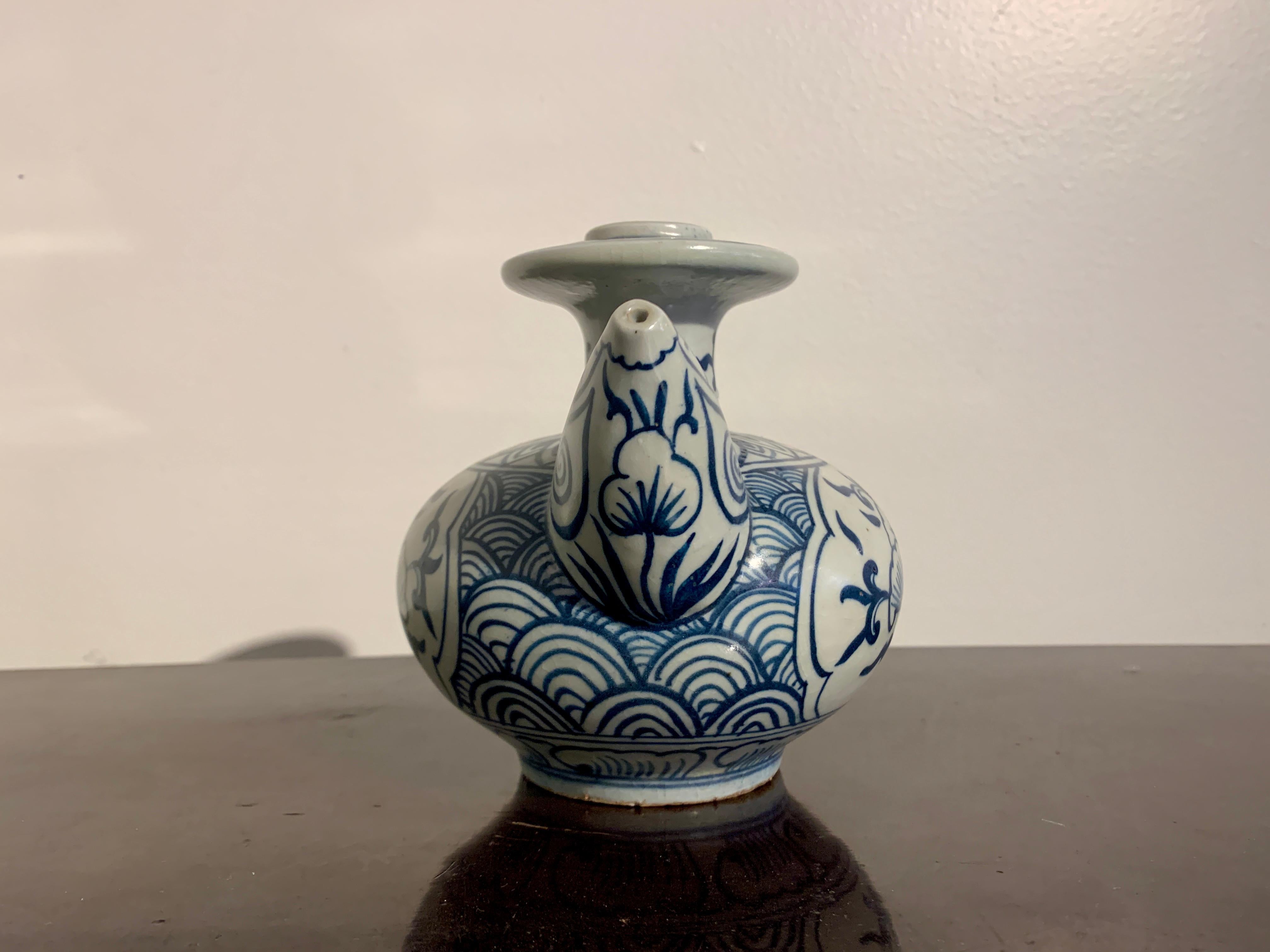 A charming small Vietnamese shipwreck porcelain kendi, or pouring vessel, with blue and white decoration, late 15th or early 16th century, Vietnam. 

The small kendi is heavily potted, with a squat body, short neck, flanged mouth, and a large,