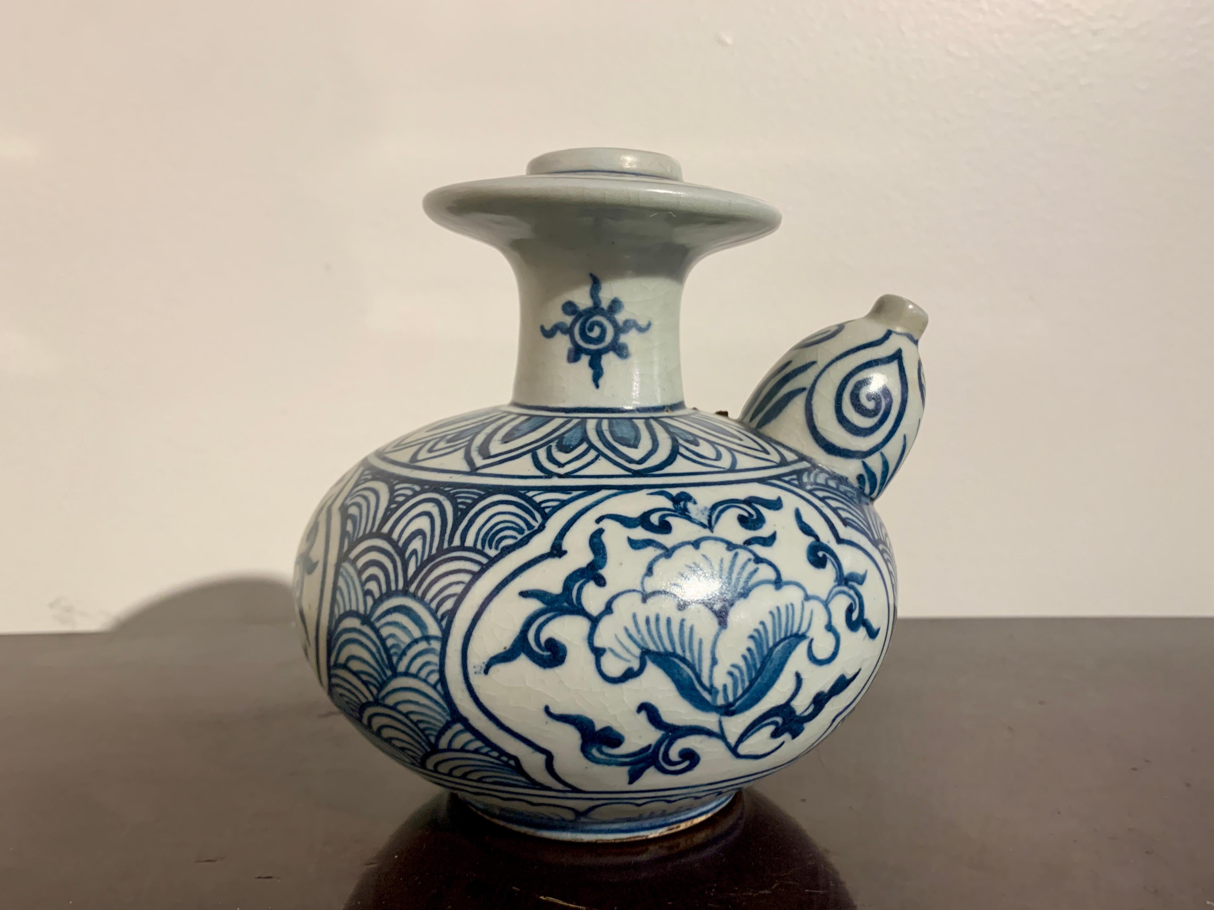 A charming small Vietnamese shipwreck porcelain kendi, or pouring vessel, with blue and white decoration, late 15th or early 16th century, Vietnam. 

The small kendi is heavily potted, with a squat body, short neck, flanged mouth, and a small yet