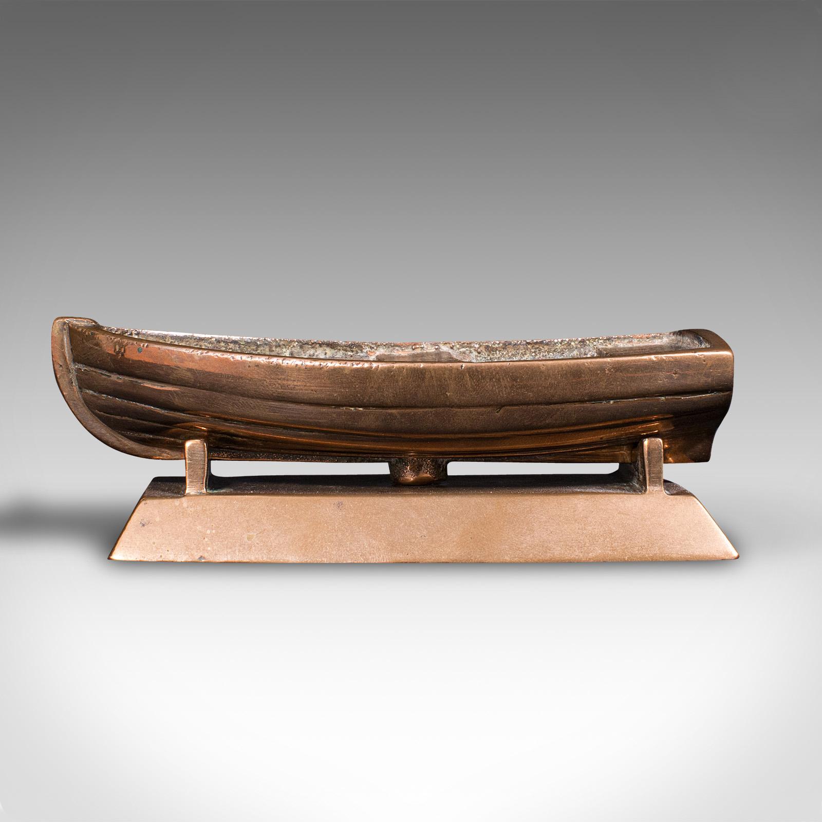 This is a small vintage model boat. A Continental, bronze desk ornament or decorative coin tray, dating to the mid 20th century, circa 1950.

Tactile and charming ornament, redolent of a small fishing vessel
Displays a desirable aged patina