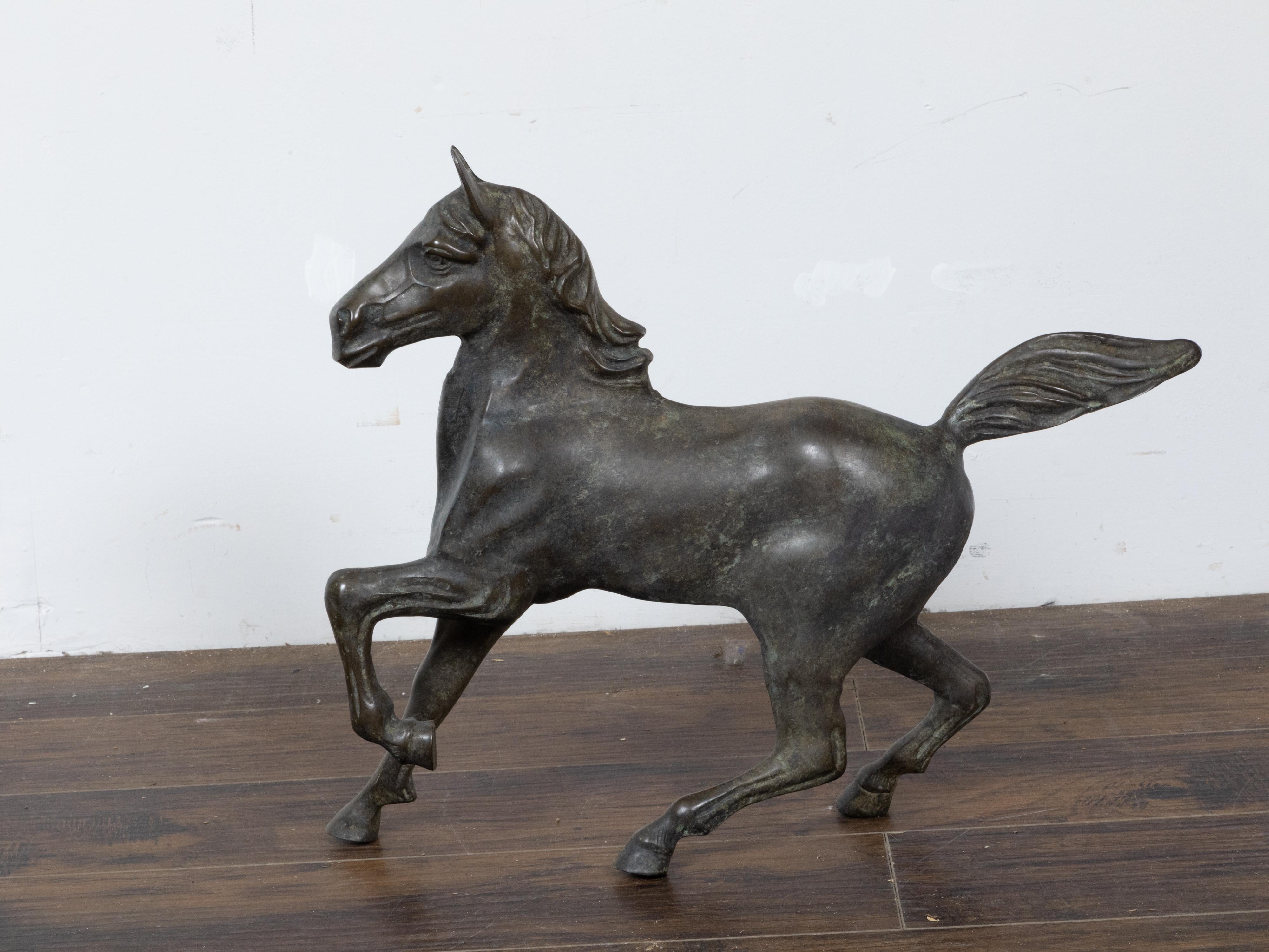 A small vintage bronze horse sculpture with dark patina and energetic pose. Discover the dynamic allure of this vintage bronze horse sculpture, a captivating piece that masterfully encapsulates the vigor and spirit of this majestic creature. Though