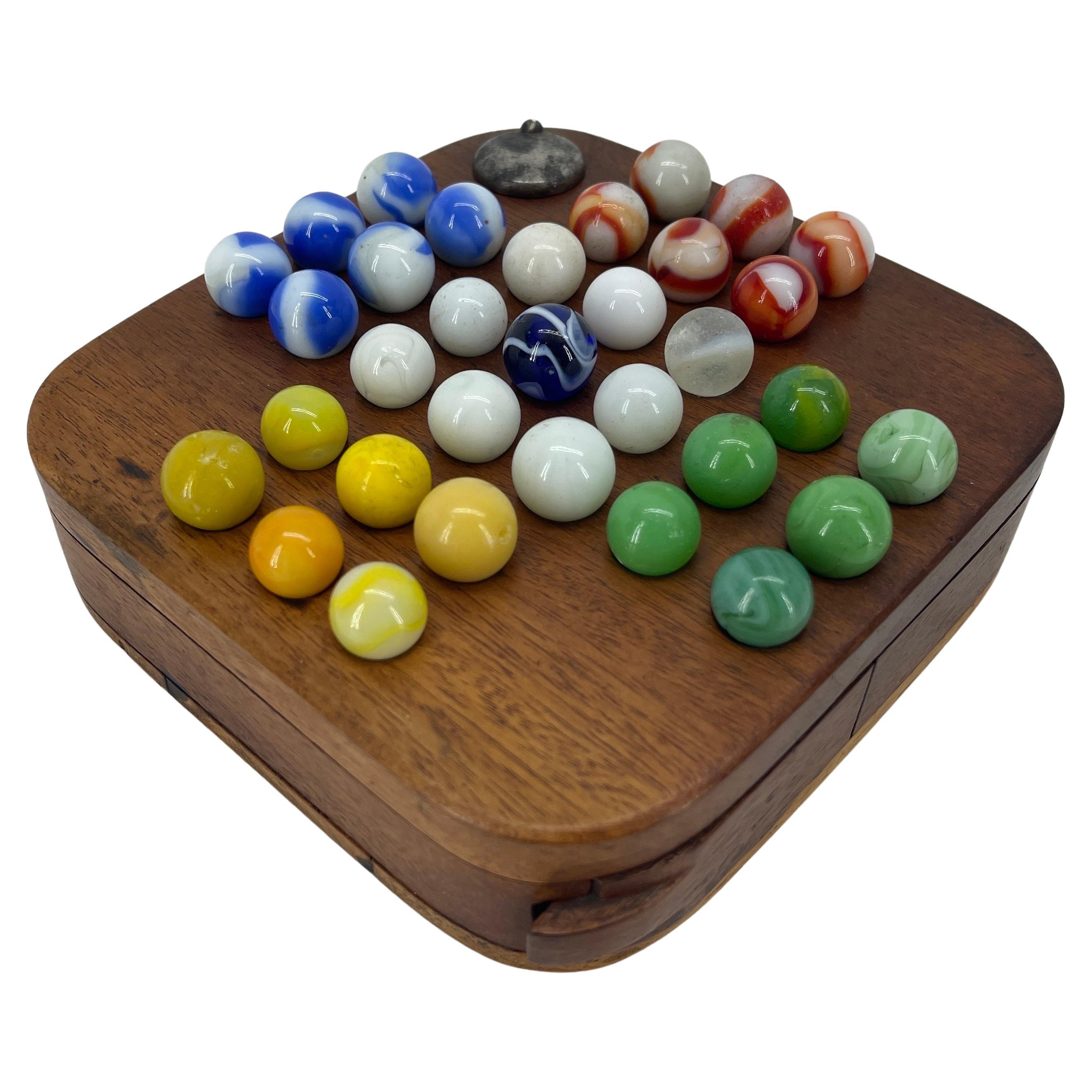 Small Wood Board Game With 31 Glass Balls For Chinese Checkers. The board has an internal compartment to store the glass balls.


