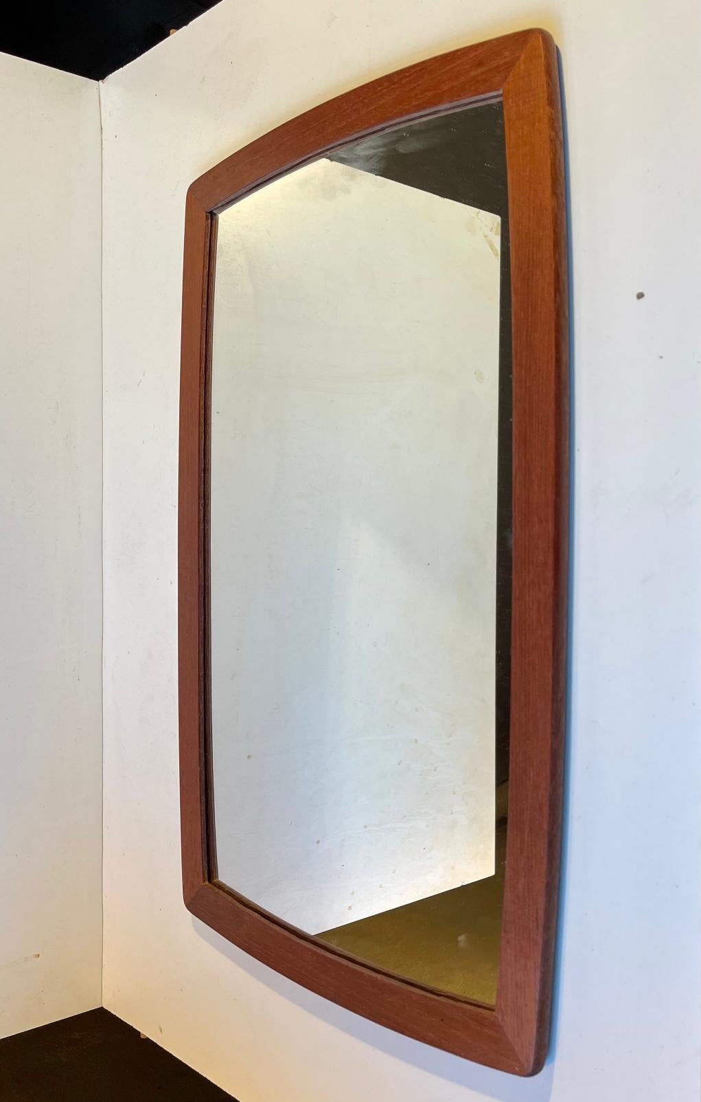 A small wall hung mirror with solid teak profiles. It was manufactured in Denmark during the 1960s. Wellkept original condition. Measurements: 52x32.5 cm.