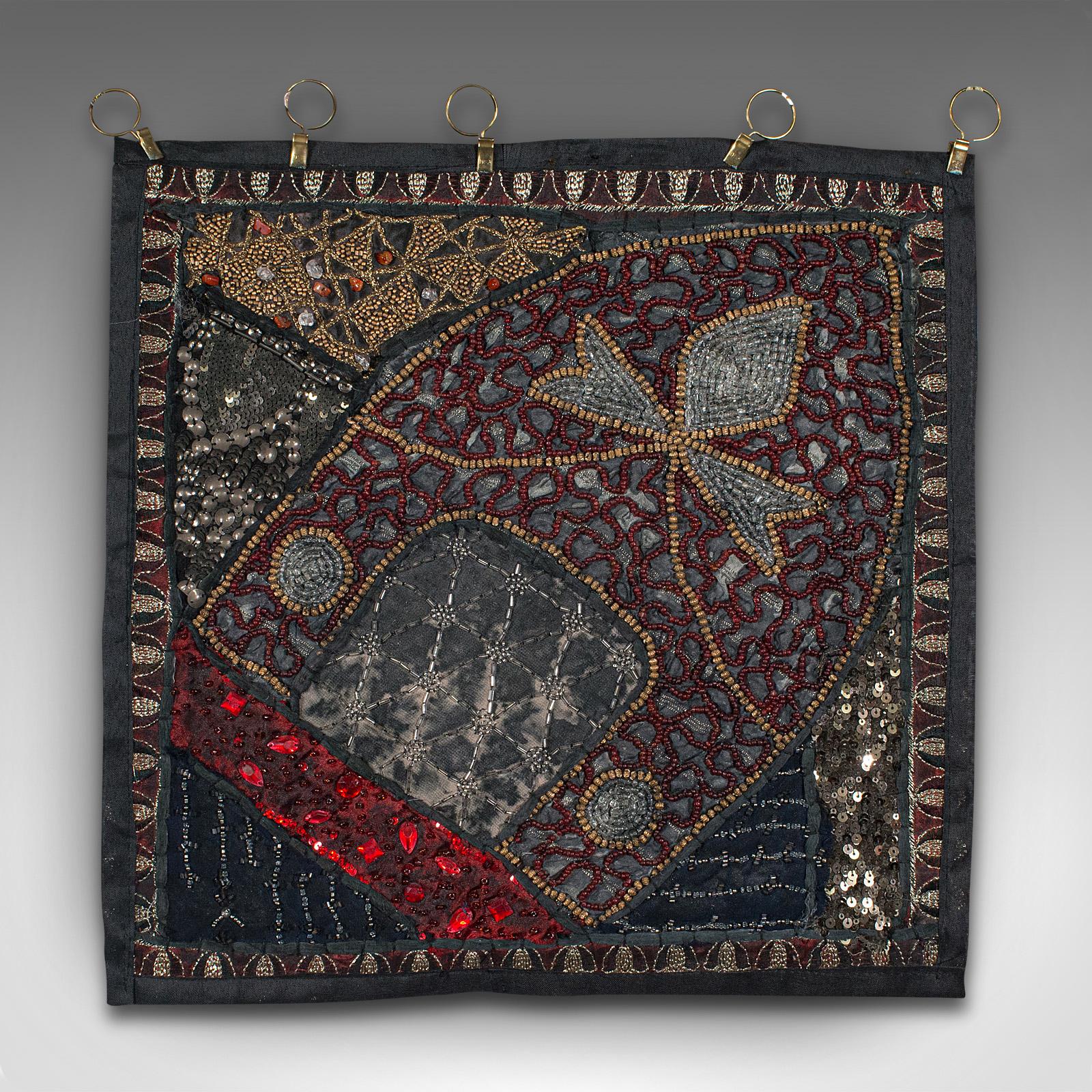 This is a small vintage decorative wall panel. A Middle Eastern, ornate square textile frieze with sequins and faux gemstones, dating to the late 20th century, circa 1980.

Distinctively decorated square panel with eye-catching finish
Displays a
