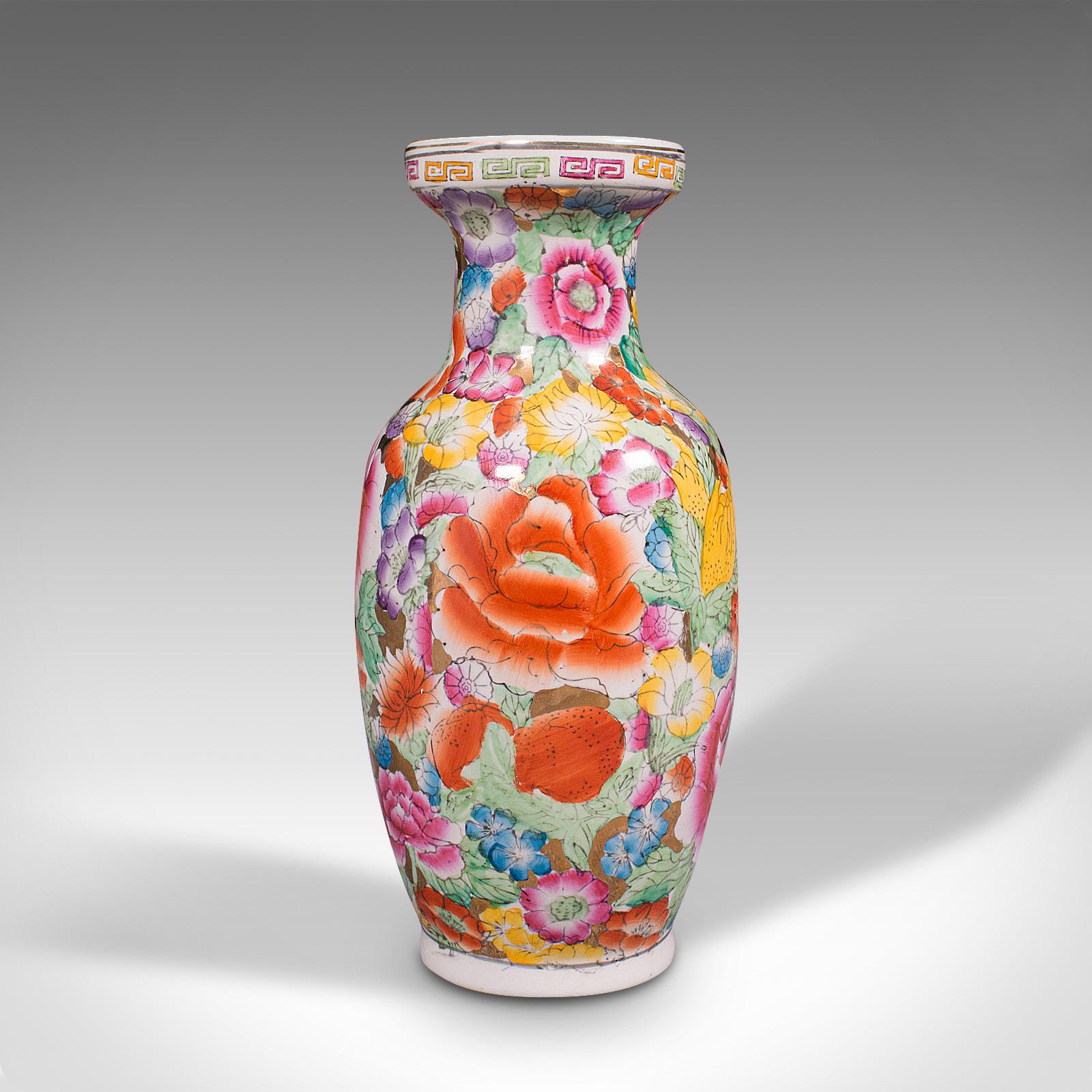 This is a small vintage display vase. A Chinese, ceramic posy urn, dating to the mid 20th century, circa 1950.

Copious decorations present a colourful visage
Displaying a desirable aged patina throughout
Decorated with flower heads with a gamut