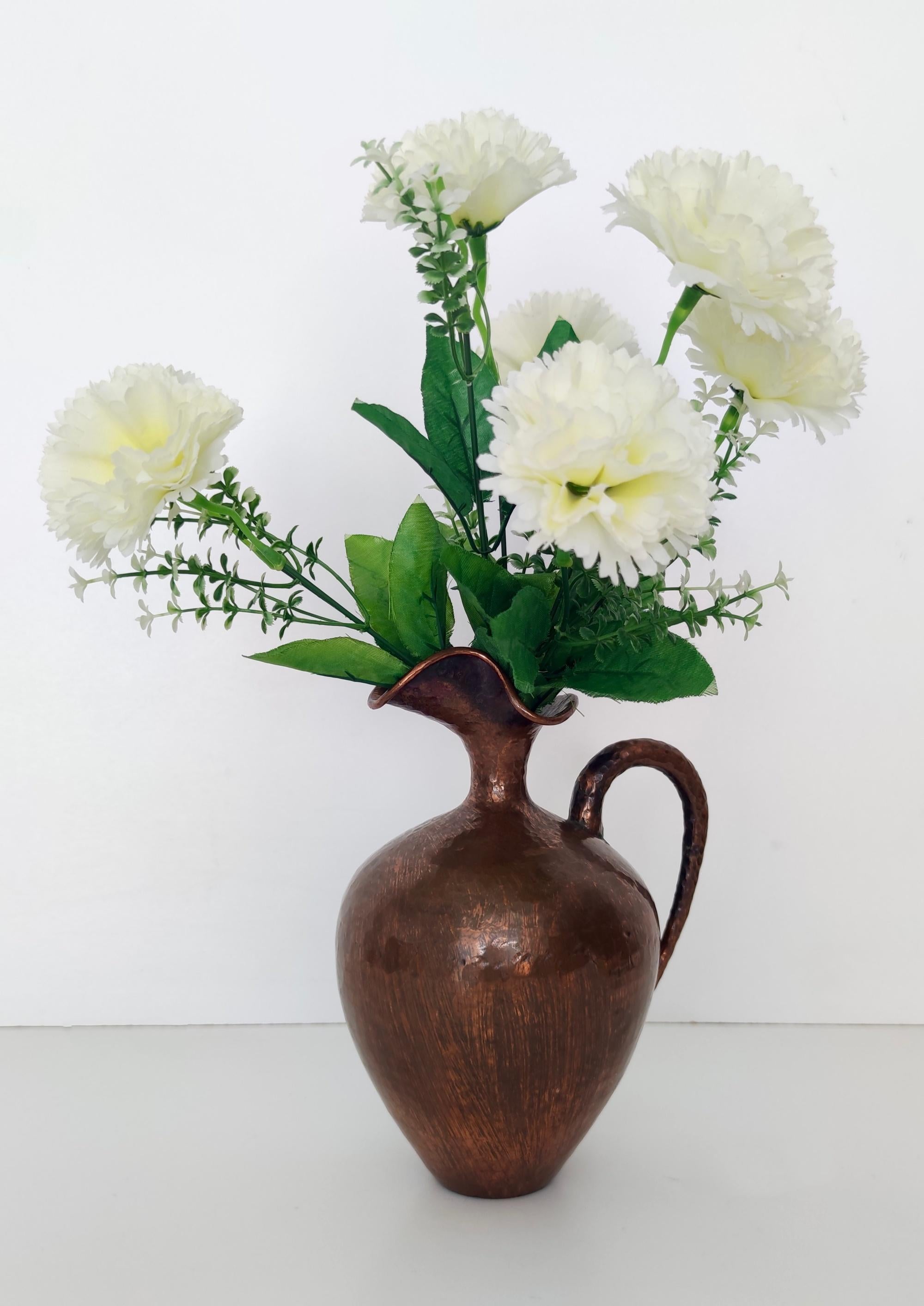 Fabriqué en Italie, années 1950.
Ce vase-pichet est fabriqué en cuivre repoussé. 
Il est minimal et classique, mais reste moderne. Son design incarne parfaitement l'esprit de l'époque. 
Il s'agit d'une pièce vintage, elle peut donc présenter de