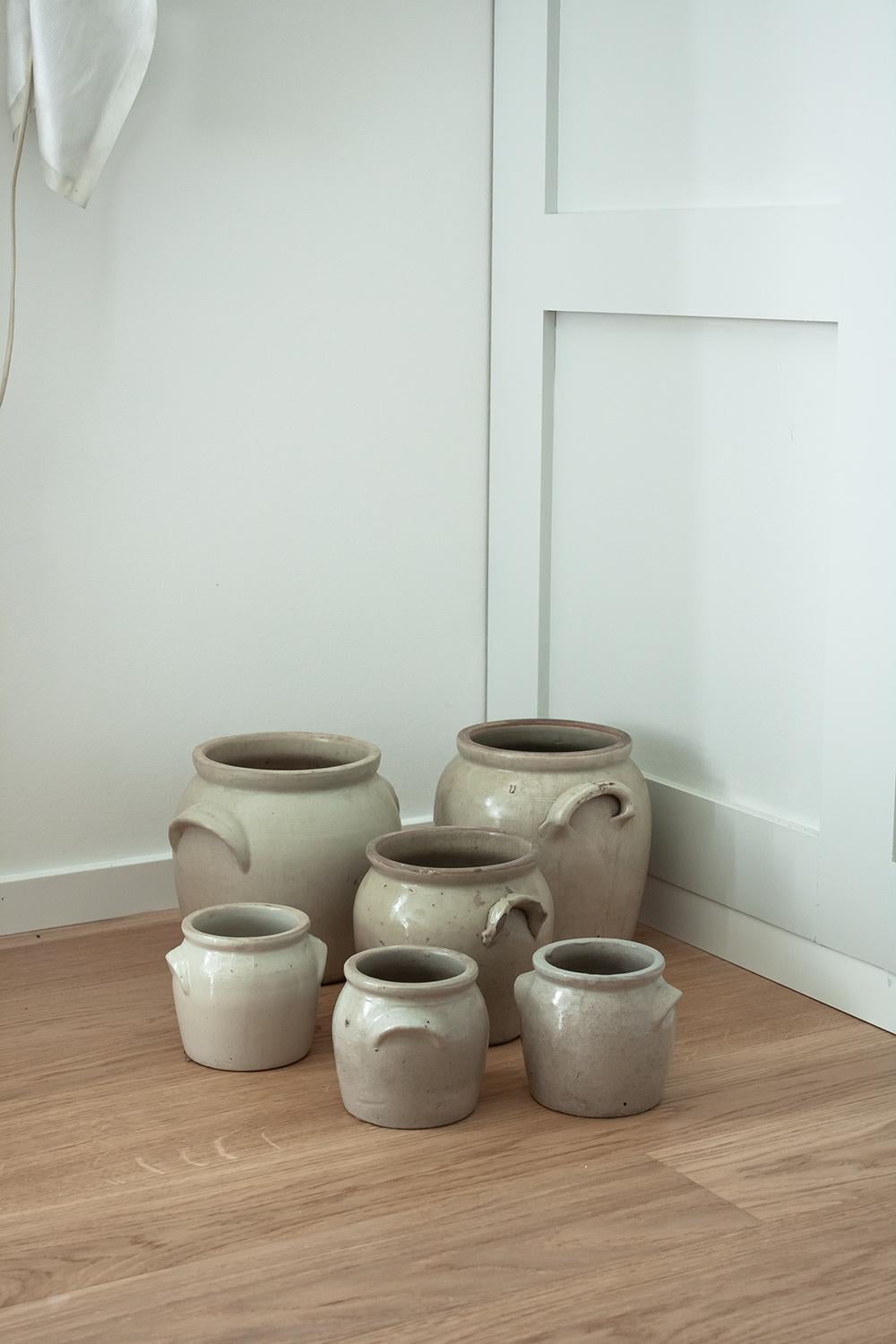 Available are 3 same-sized french stoneware crocks. Individually sourced in the south of France, this set of glazed stoneware crocks is a staple of any French kitchen or interior. Used as storage vessels or flower vases, these crocks will add a