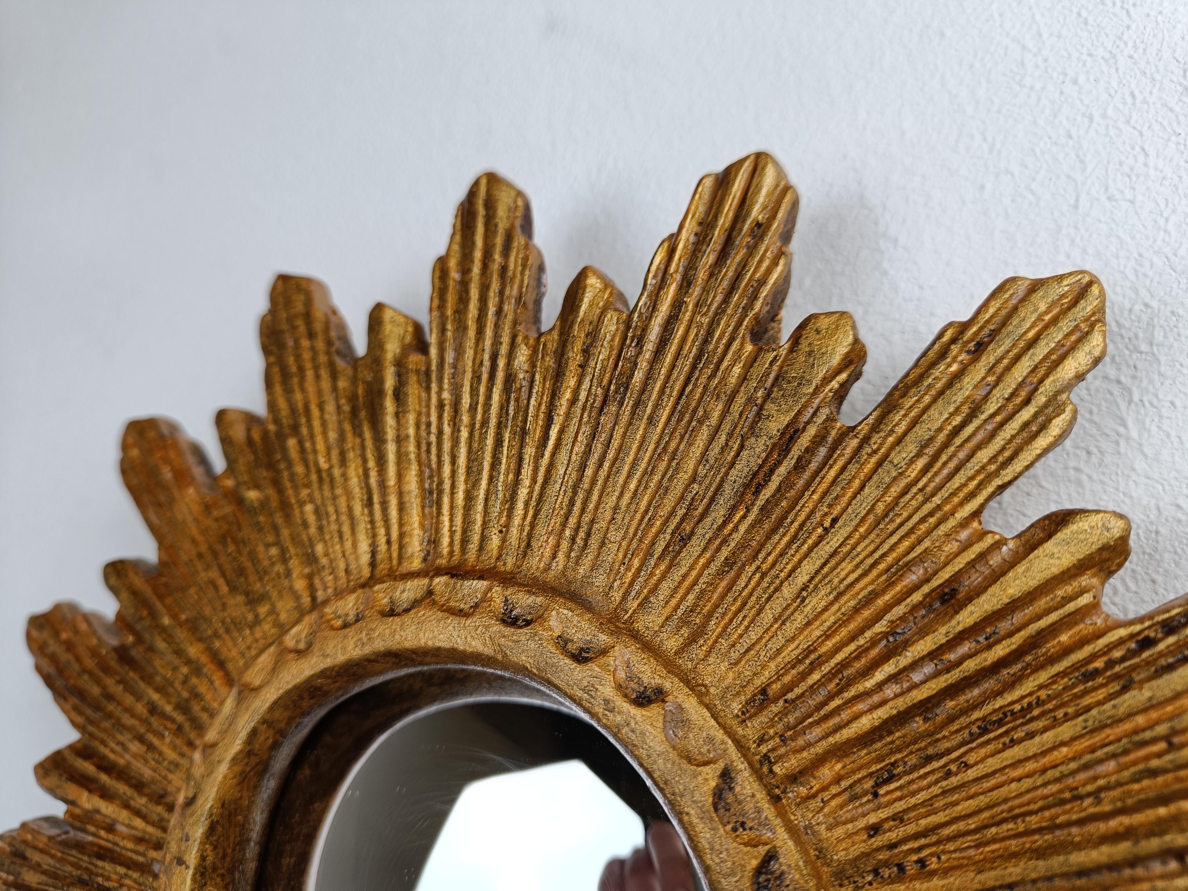 Gilded resin sunburst mirror with convex mirror glass.

The golden mirror is in a good condition.

1960s - made in Belgium.

Dimensions:
Diameter: 25cm/9.84