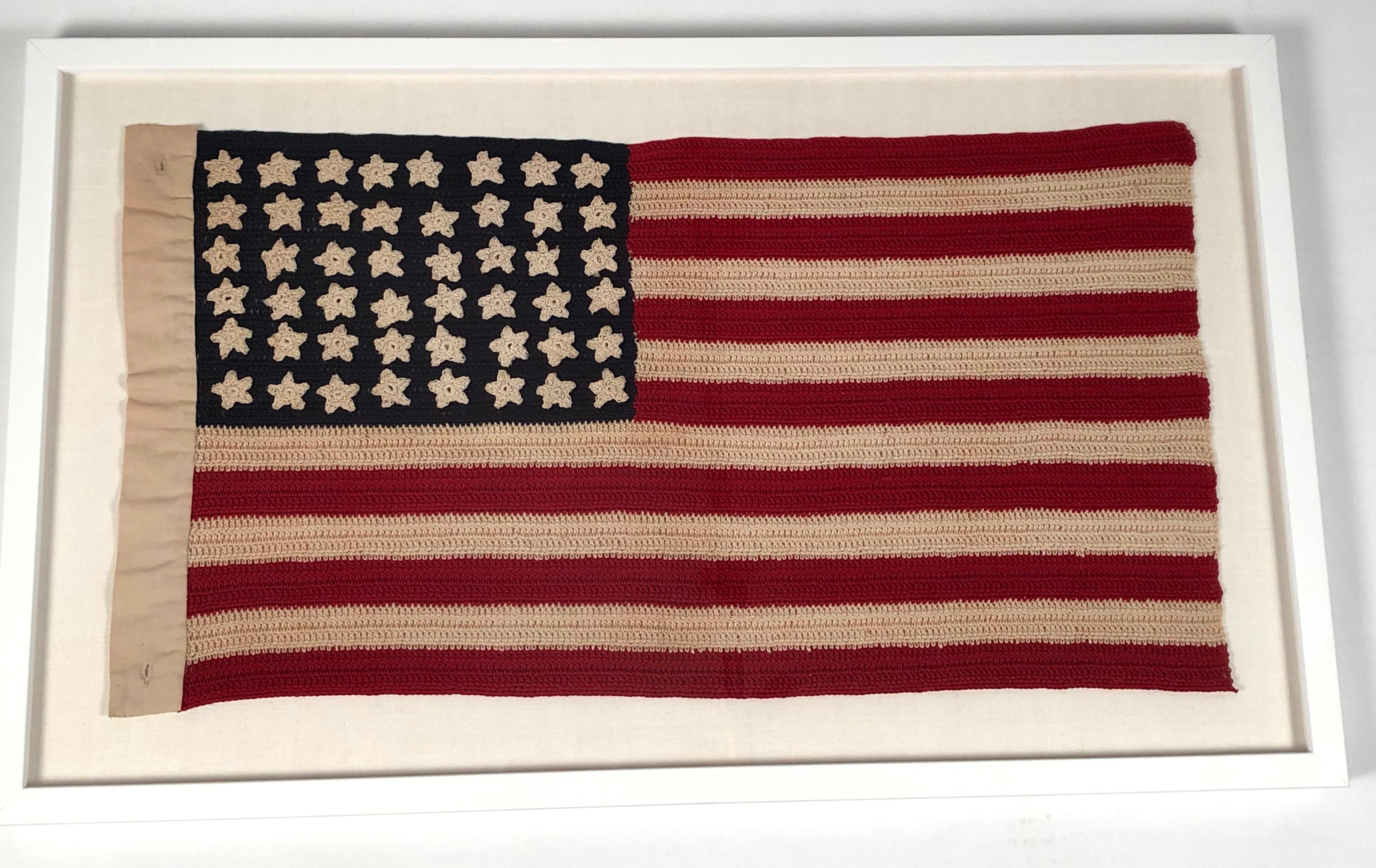 A vintage, hand crocheted 48 star American flag, with new, archival hand sewn mounting on acid free oyster white linen covered matte board, in a white lacquered frame with UV-resistant glass. These flags were made by patriotic women in the 1940s and