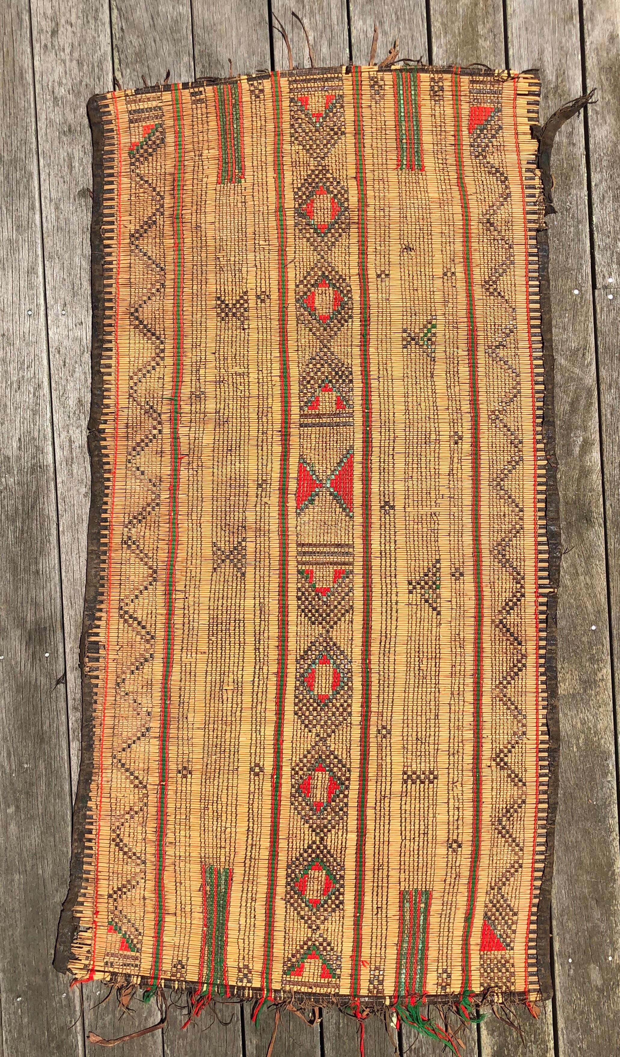 This vintage Tuareg Mat rug was fastidiously made by hand in the early years of the 20th century. Using local reeds and other natural materials and dyes, these mats are woven and then decorated using leather strands. Made in the first years of the