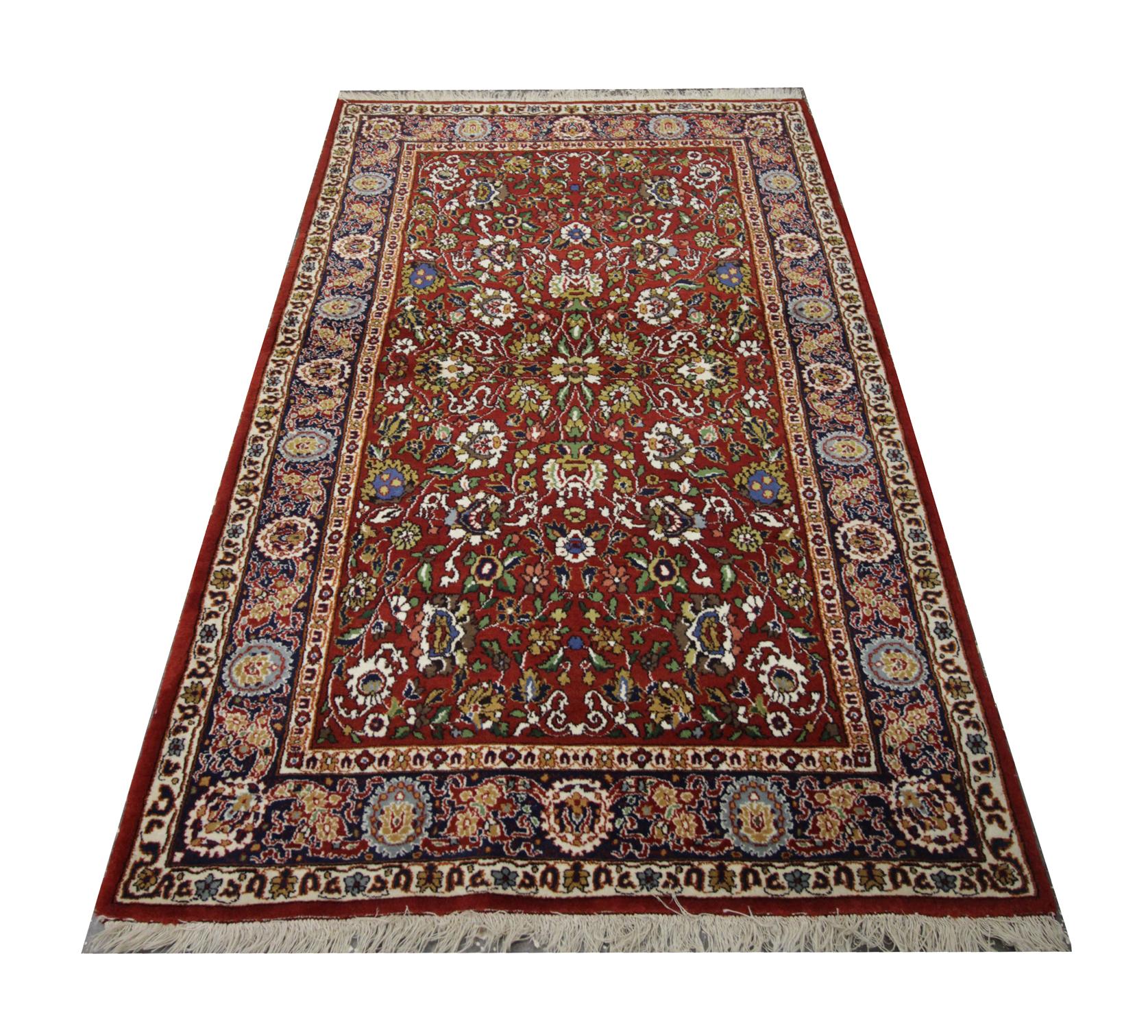 This elegant wool rug was woven by hand in India in the 1960s. Constructed with a fantastic design and colour palette, including deep red, green, mustard and ivory. The floral design features delicately woven motifs and medallions symmetrically