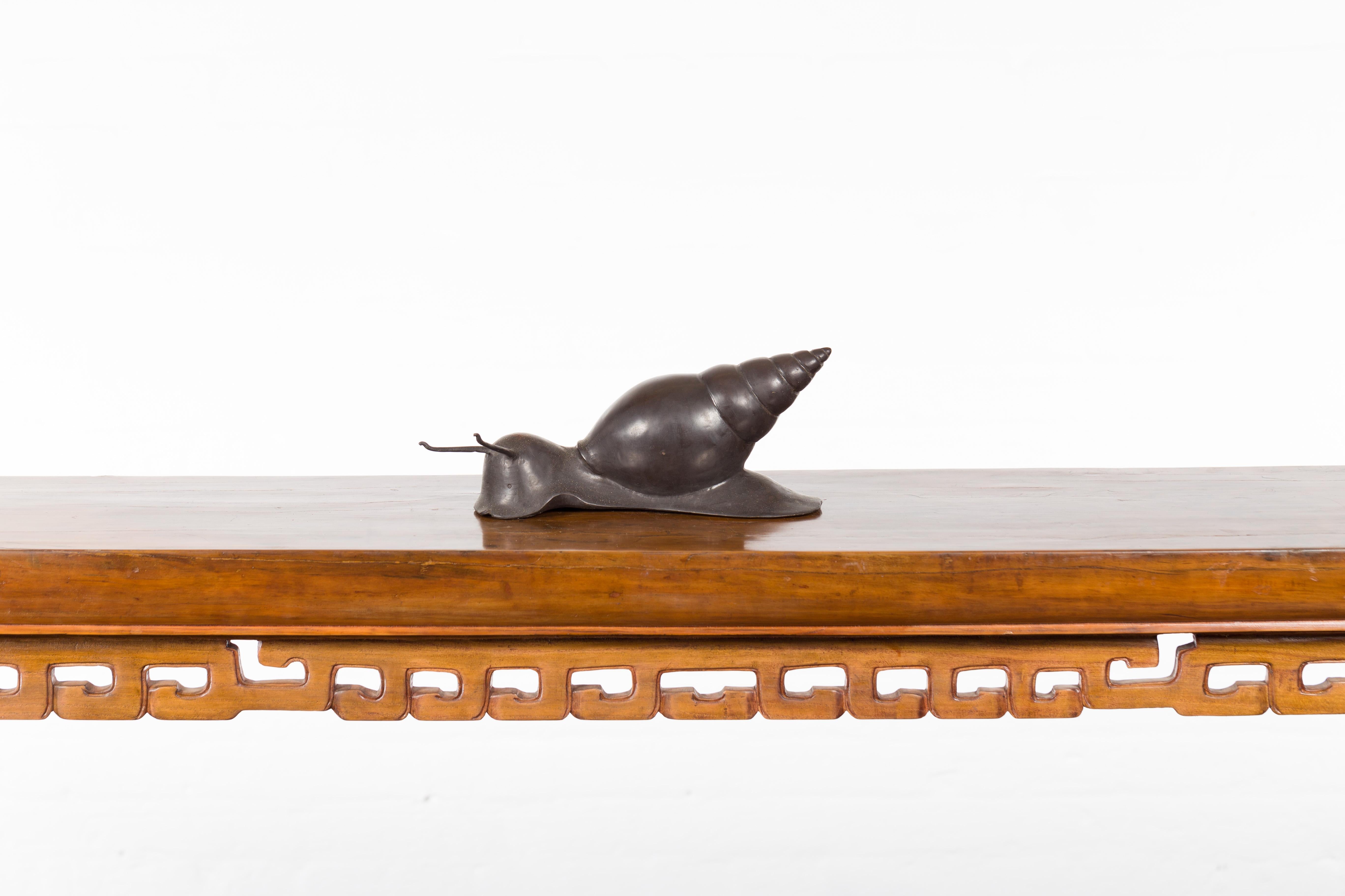 A vintage lost wax cast bronze snail sculpture from the mid 20th century with dark patina. We have several available. Created with the traditional technique of the lost-wax (à la cire perdue) which allows for great precision and finesse in the