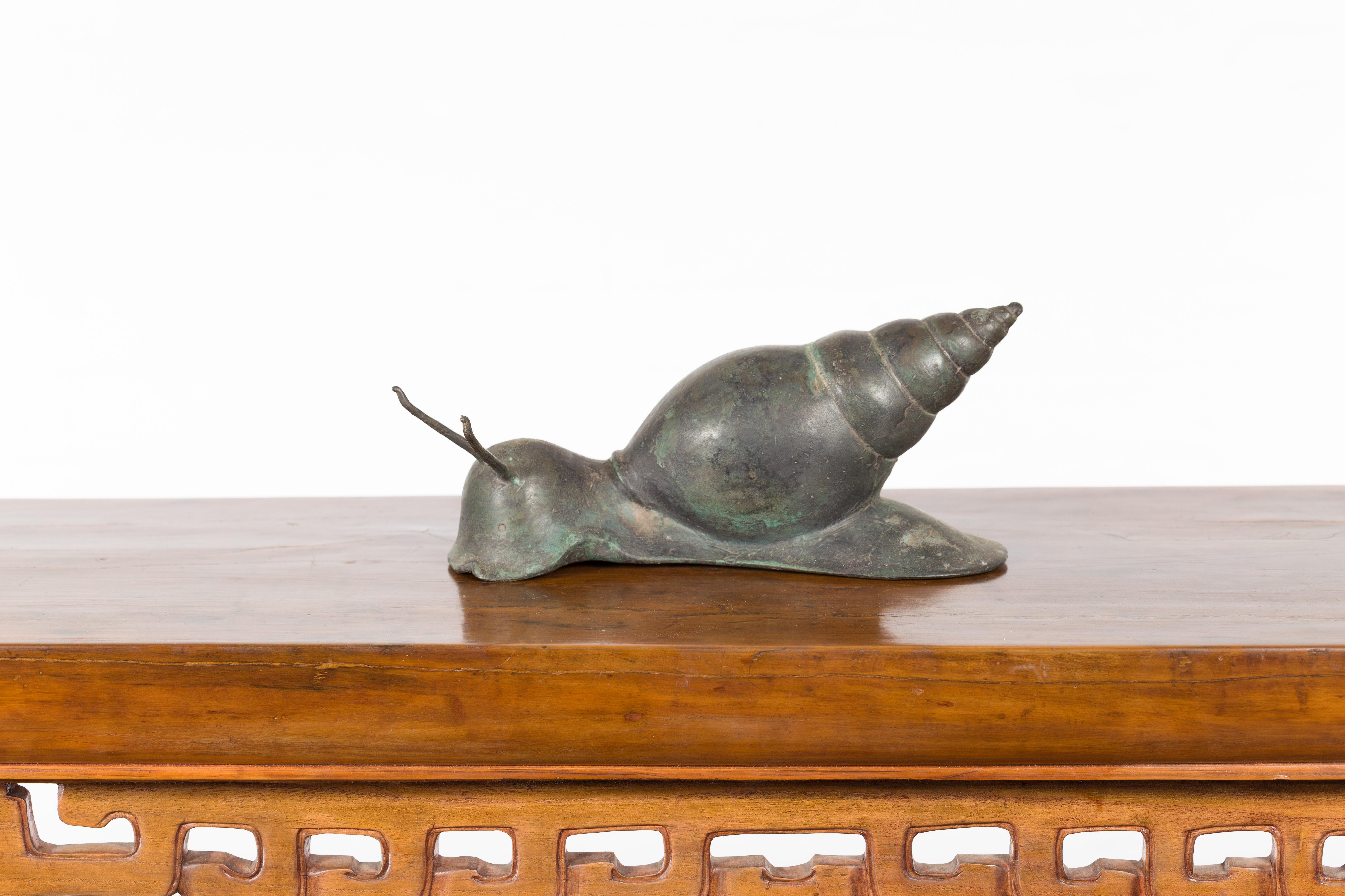 Escultura vintage de caracol de bronce fundido a la cera perdida de mediados del siglo XX con pátina verde. Tenemos varios disponibles. Creada con la técnica tradicional de la cera perdida (à la cire perdue), que permite una gran precisión y