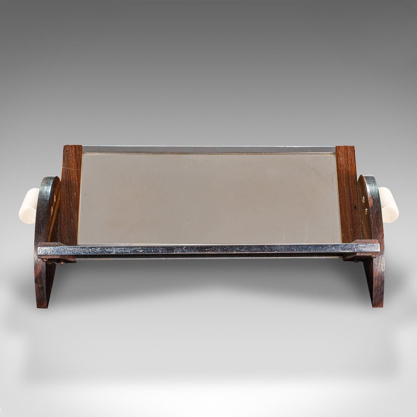 
This is a small vintage mirrored book trough. An English, rosewood and glass angled novel rest, dating to the Art Deco period, circa 1940.

Unusual and fascinating book trough, with superb mirrored finish
Displays a desirable aged patina and in