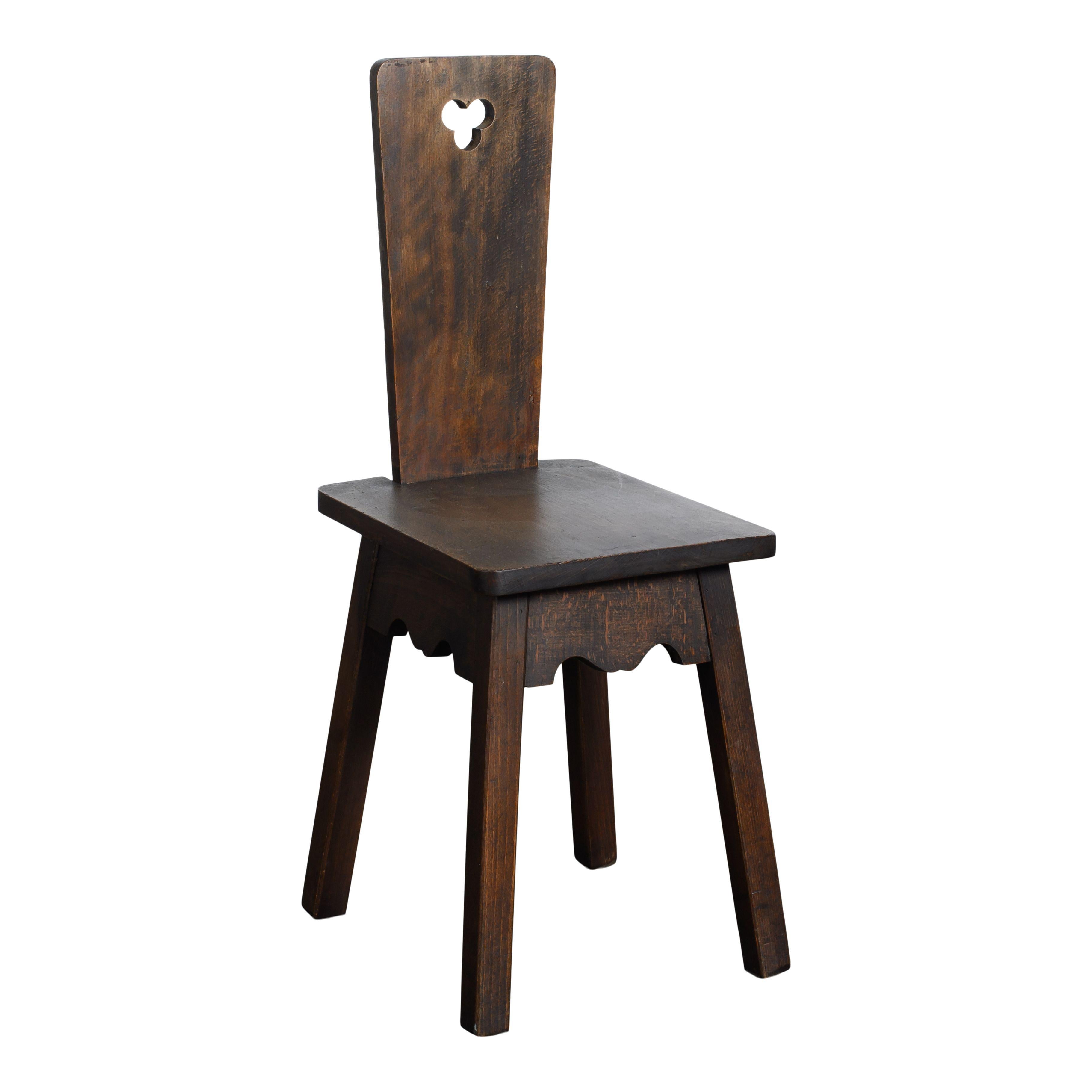 Set of 4 vintage dark wood chairs with cutout details in the Moravian style. These chairs are simple but unique and offer an interesting silhouette to any space. The base is small and square with four straight square legs that flare out and
