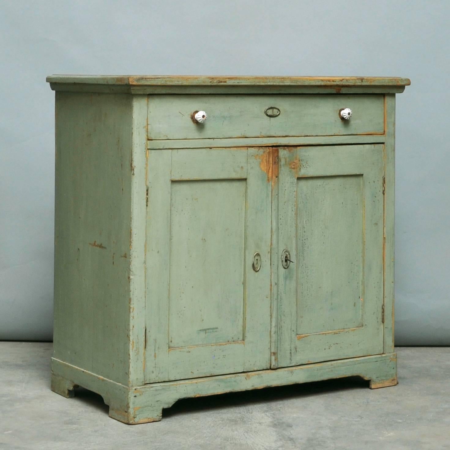 This small cabinet from the 1930s is made of pine. It features its original green paint.