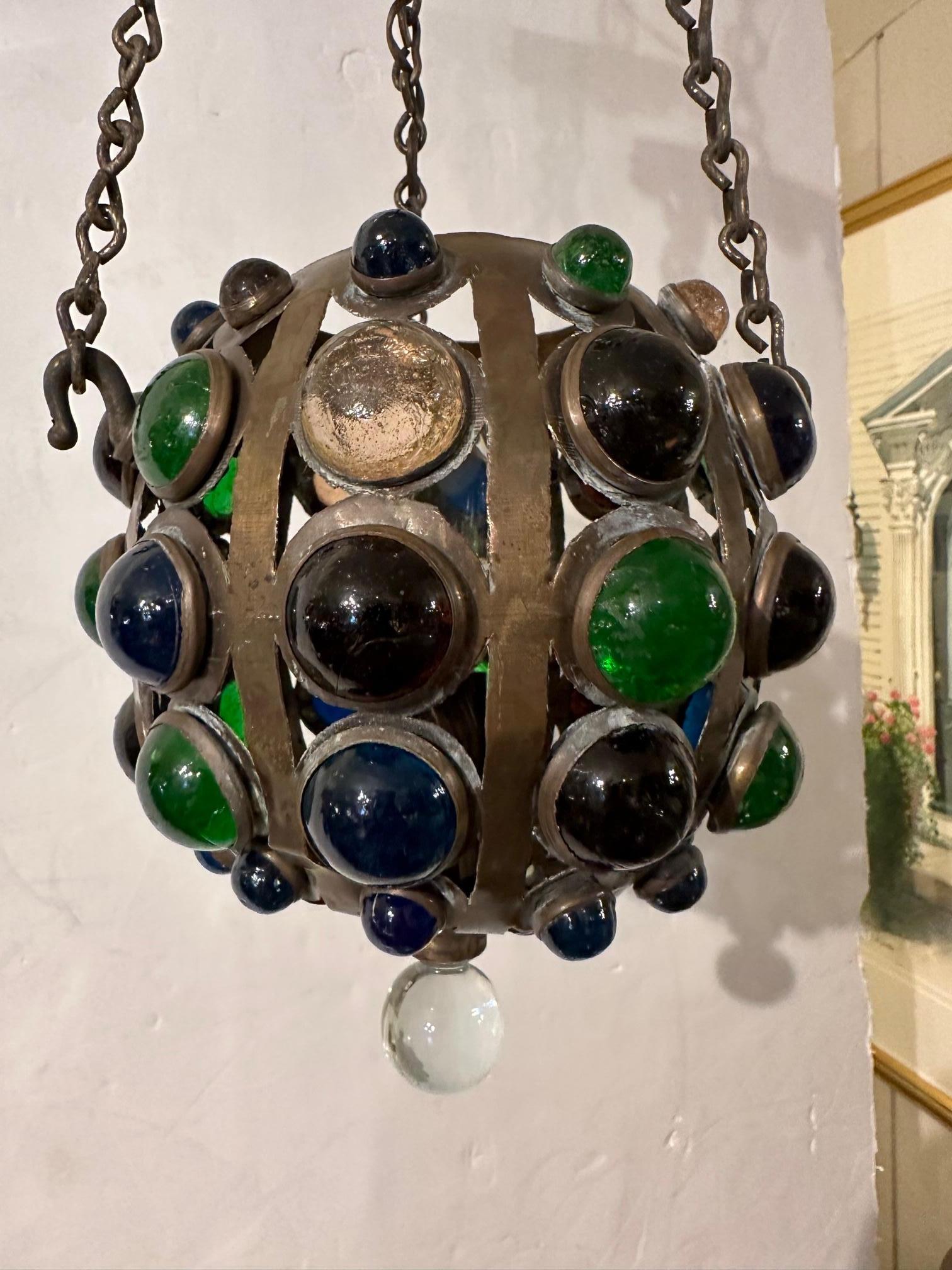 Exotic round bronze pendant encrusted with gem like domed pieces of colored glass. Comes with matching ceiling cap. Single socket. 10