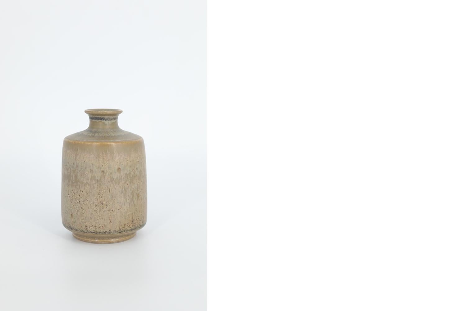 This miniature, collectible stoneware vase was designed by Gunnar Borg for the Swedish manufacture Höganäs Keramik during the 1960s. Handmade by a Master, with the utmost care and attention to details. The vase dyed brown in an irregular shade.