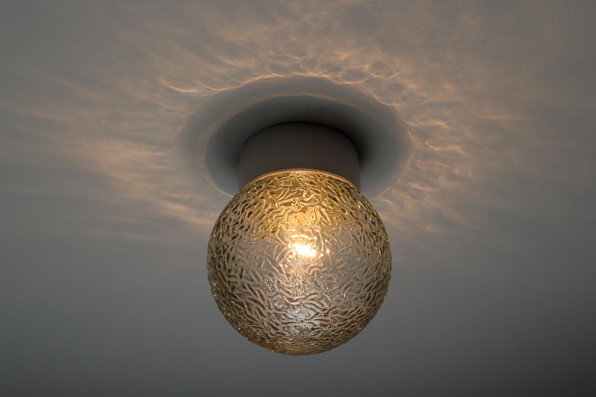 Small vintage modern wall/ceiling lights with clear bubble glass and porcelain base, France, 1960s. The glass has pattern in it, what gives a nice diffuse light effect and a nice pattern on ceiling and walls, these wall scones/ceiling lights will