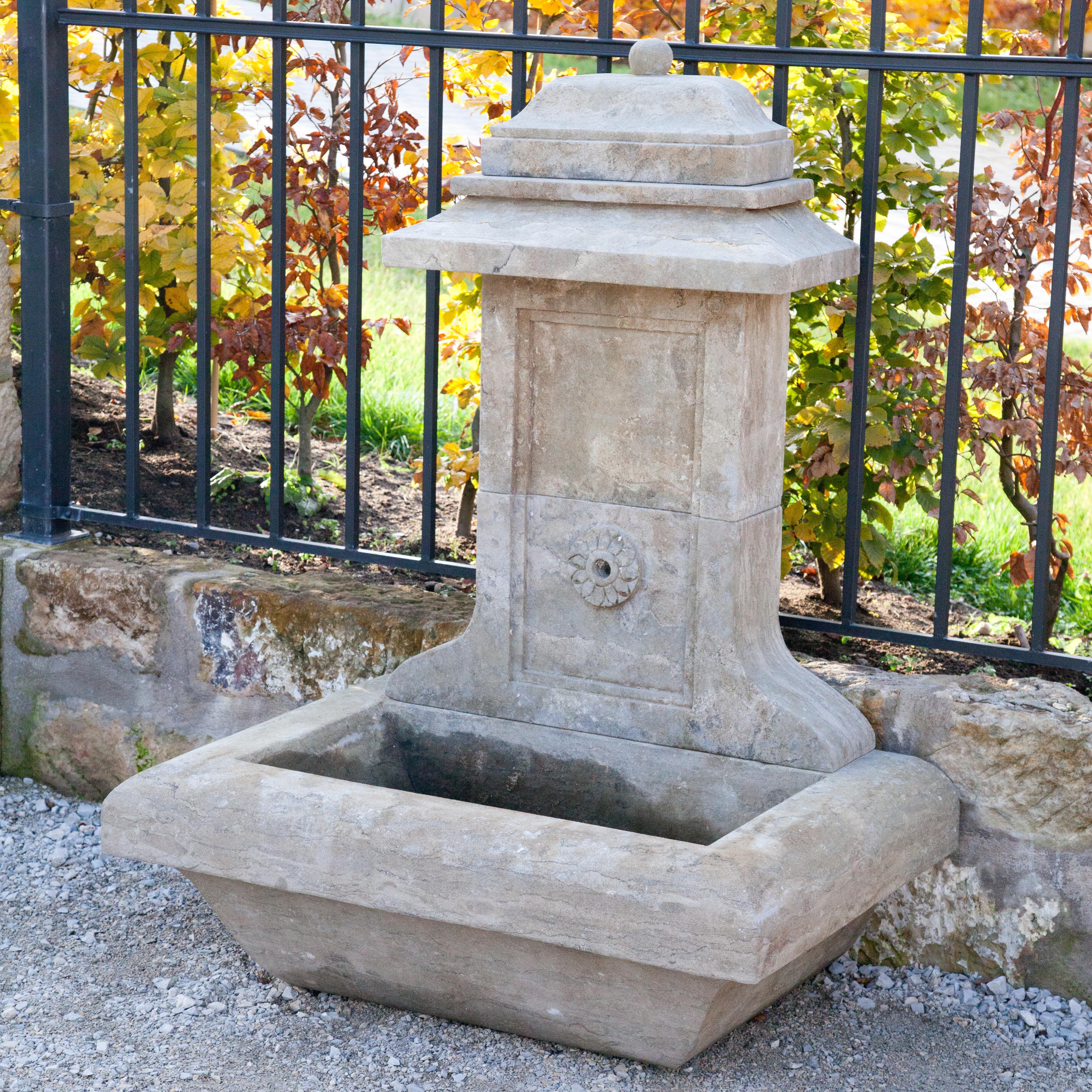 Small wall fountain with rectangular basin and narrow rear wall with profiled cornice. The spout with carved rosette decoration.