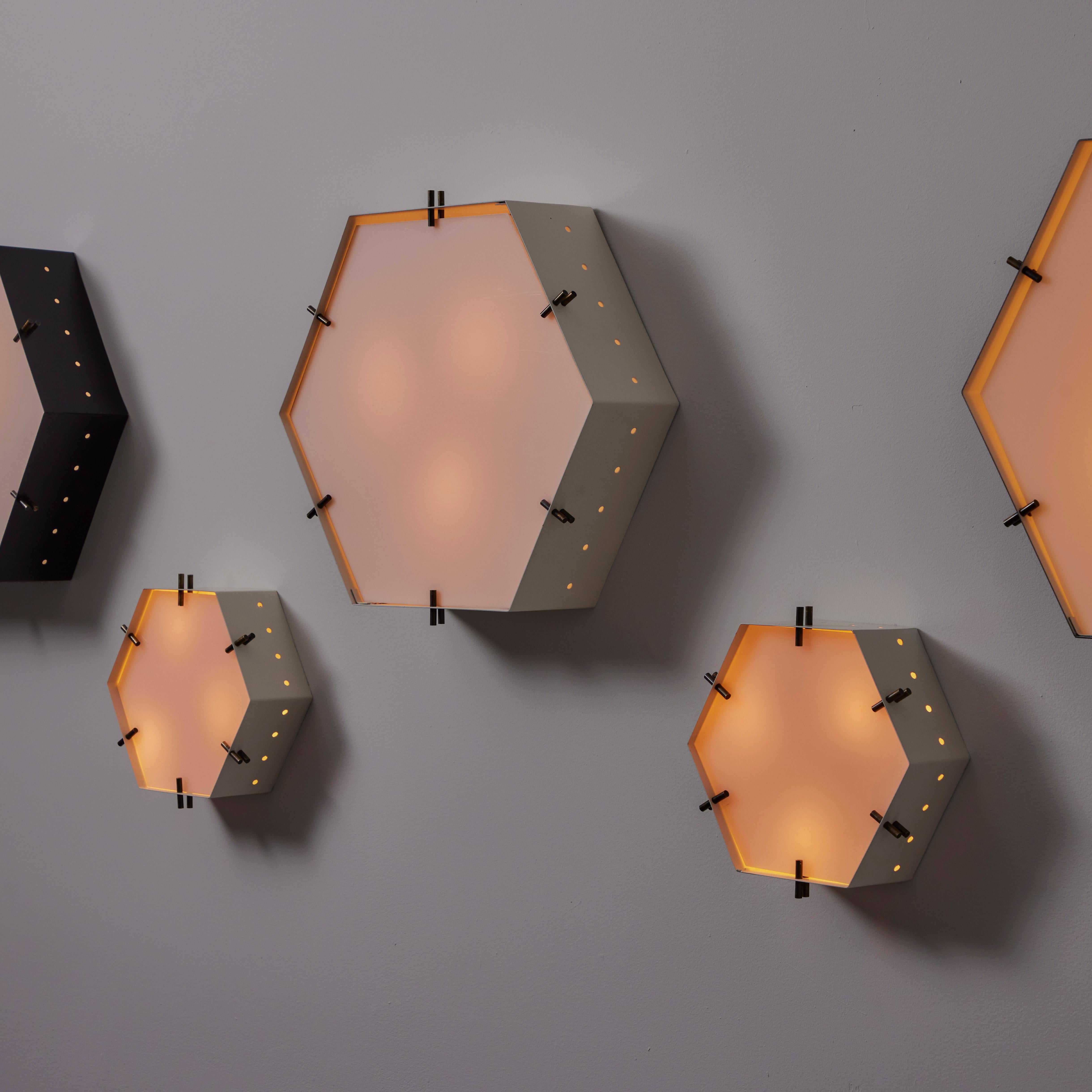 Single Small wall or ceiling light by G.C.M.E. Designed and manufactured in Italy, circa the 1950s. Hexagonal enameled frames paired with frosted acrylic. The frame features perforation around the hexagons, allowing for added light display and