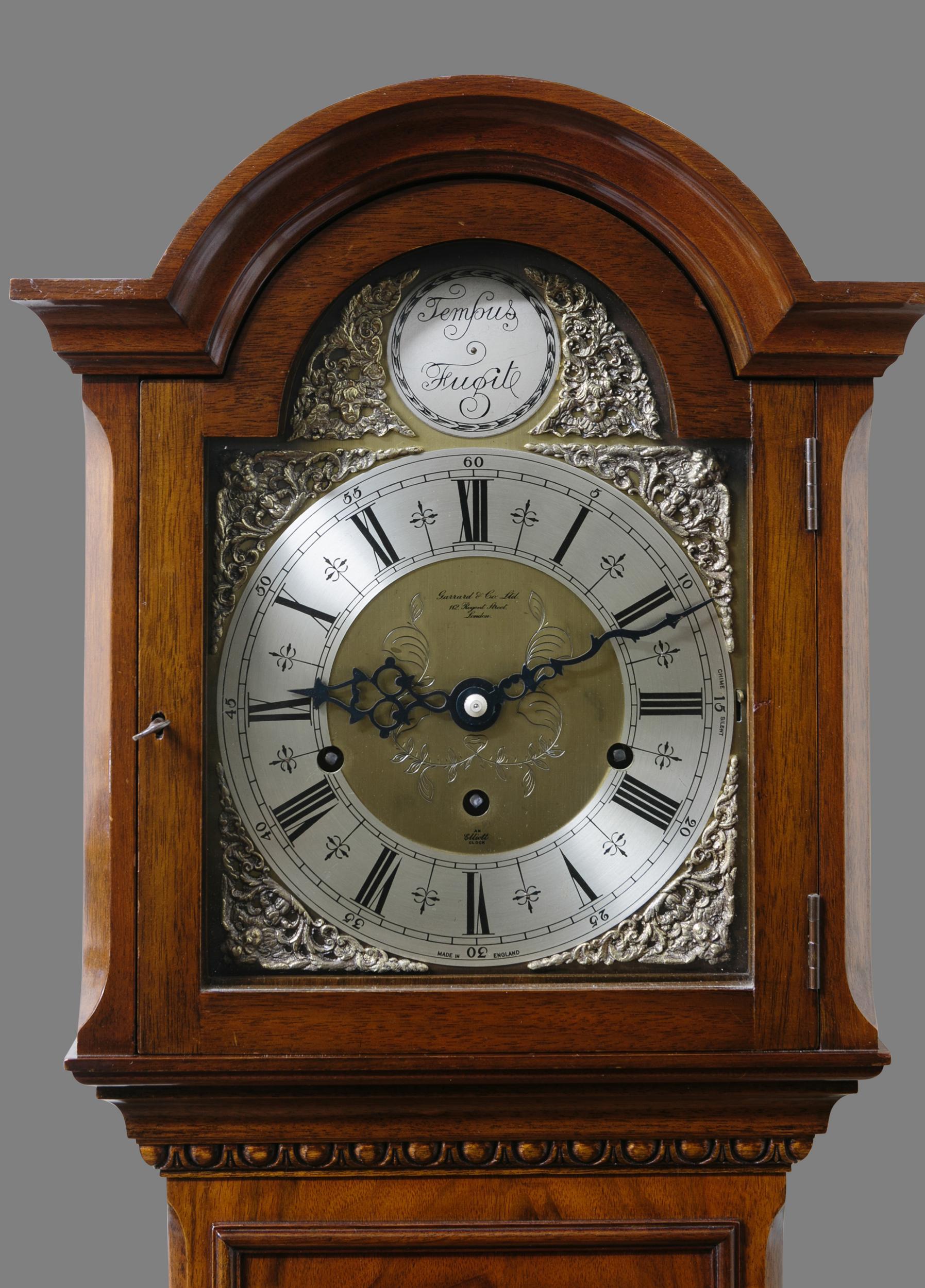 Small walnut longcase clock retailed by Garrards.

Small walnut longcase clock standing on a raised, shaped moulded plinth with applied panel to the base and carved acanthus leaf decoration.

Faux long trunk door with raised edging below the