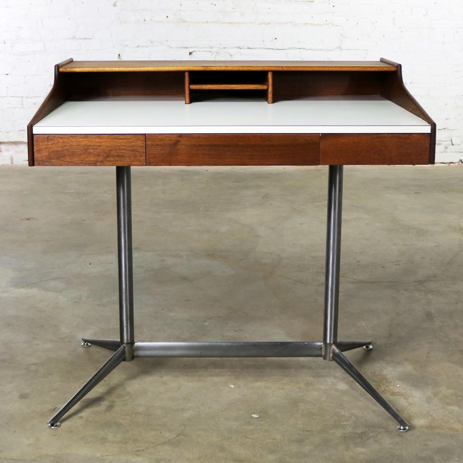 Handsome small scale Mid-Century Modern writing desk done in the style of the George Nelson swag leg desk by Herman Miller. This desk is in fabulous vintage condition. The walnut is beautiful, the white laminate top is without chips, and the steel