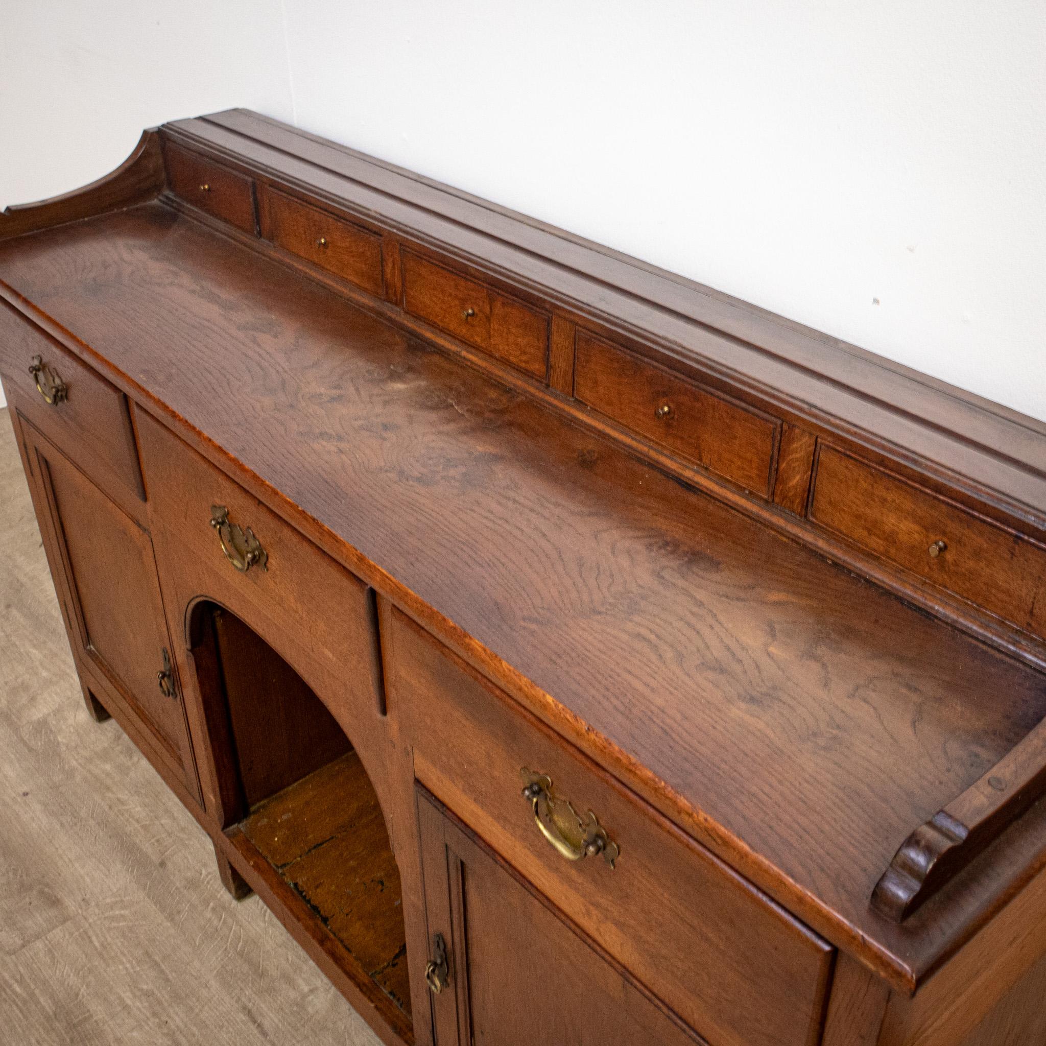 A delightful embodiment of antique charm and practicality, this small early 19th century Welsh dresser captures the enduring essence of traditional countryside aesthetics. Its upper section features a cornice and three shelves, each thoughtfully
