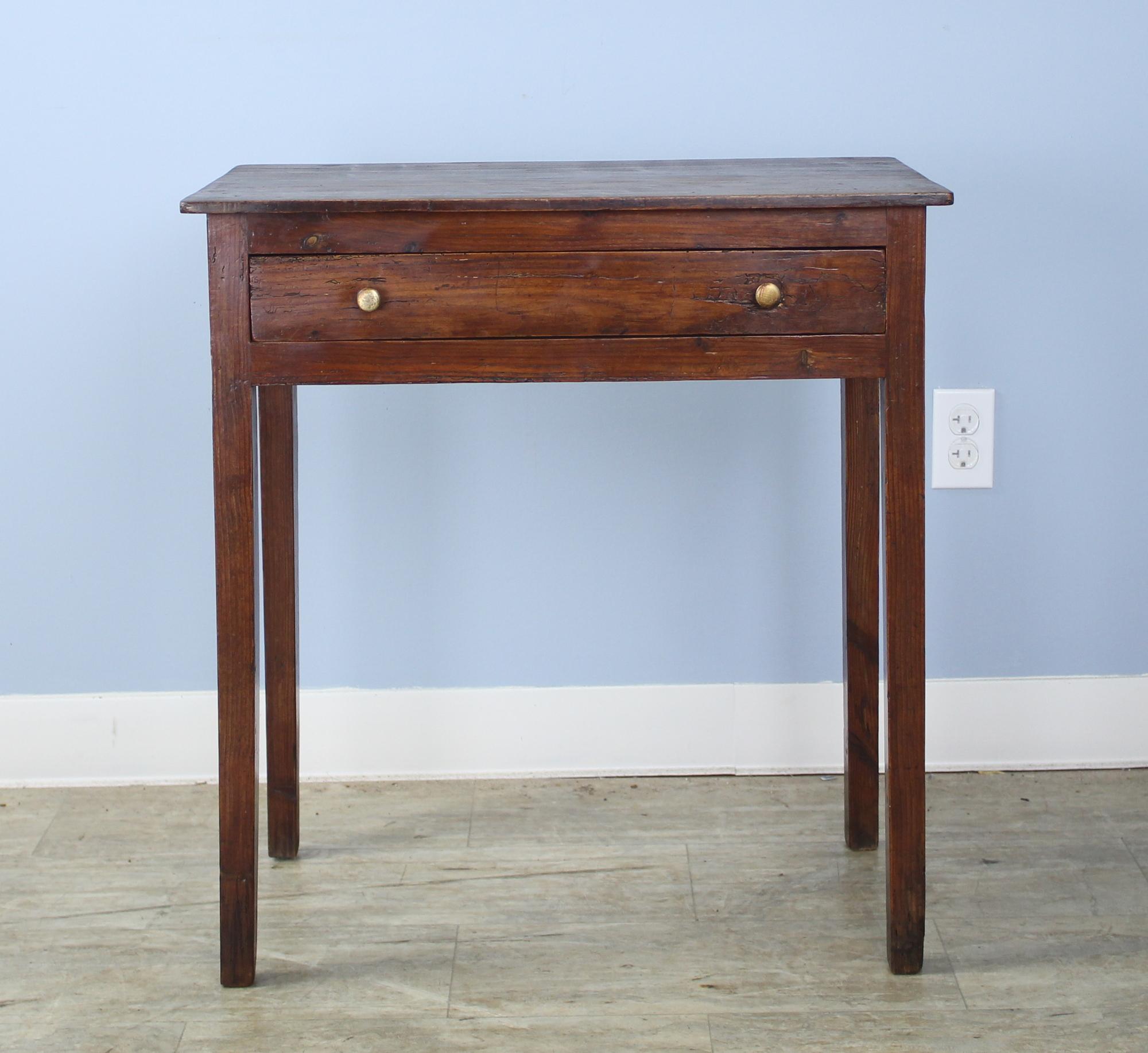 A fine Welsh period oak side table with original brass knobs and a single drawer. Good color and patina with a delicate thin top and nicely tapered legs. Would make an excellent lamp or occasional table.