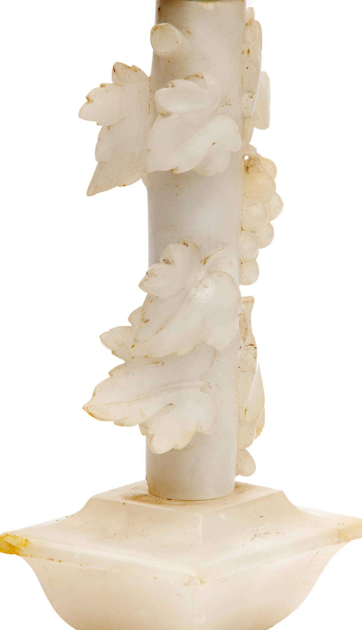 Small White Onyx Lamp: a sculptural hand carved decorative piece with carved vines wrapping around the architectural base. White onyx is delicate marble. The piece though not perfect is in beautiful condition.
Silk Bell Shade is included.