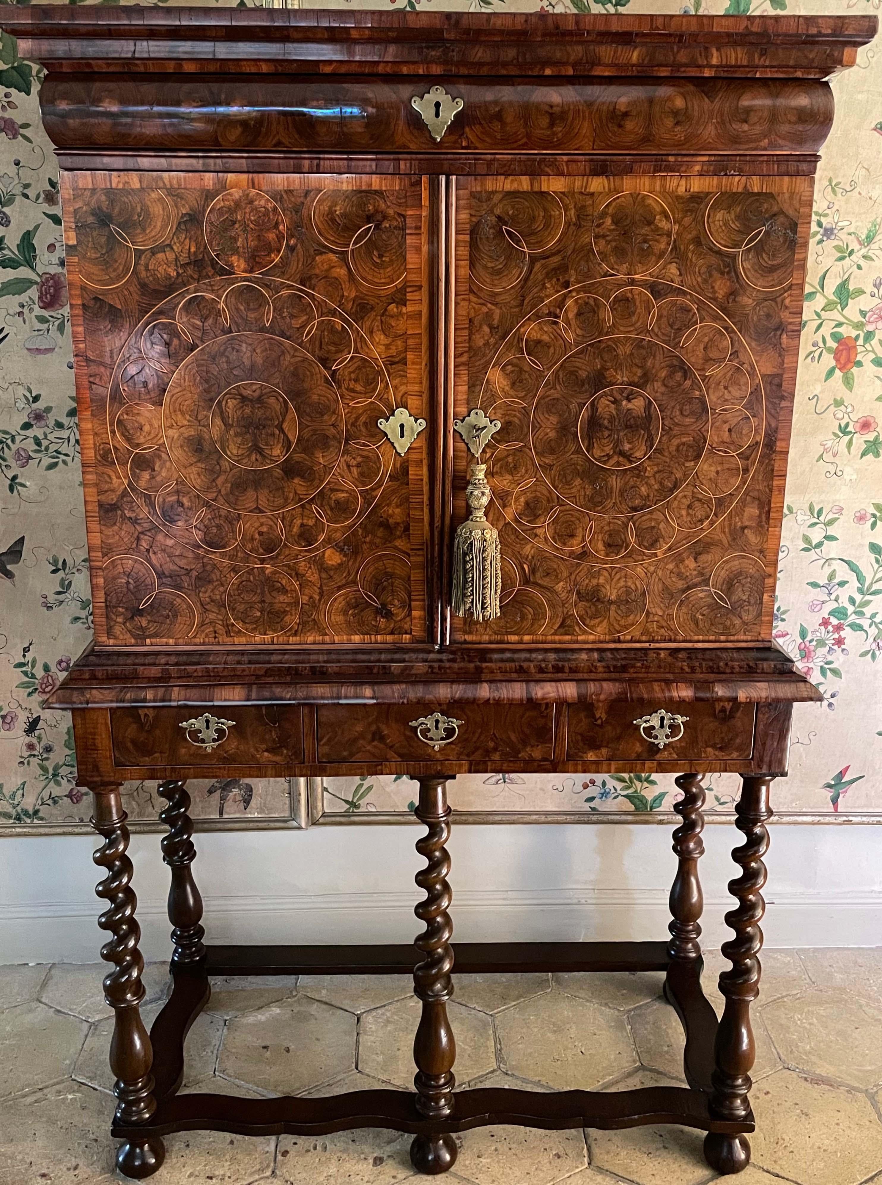 William & Mary period oyster olive wood cabinet on stand of unusually small size. Ca 1685.

The oyster inlays are of superb quality, and it is rare to find one of such small proportions. The two cabinet doors open to reveal numerous small drawers