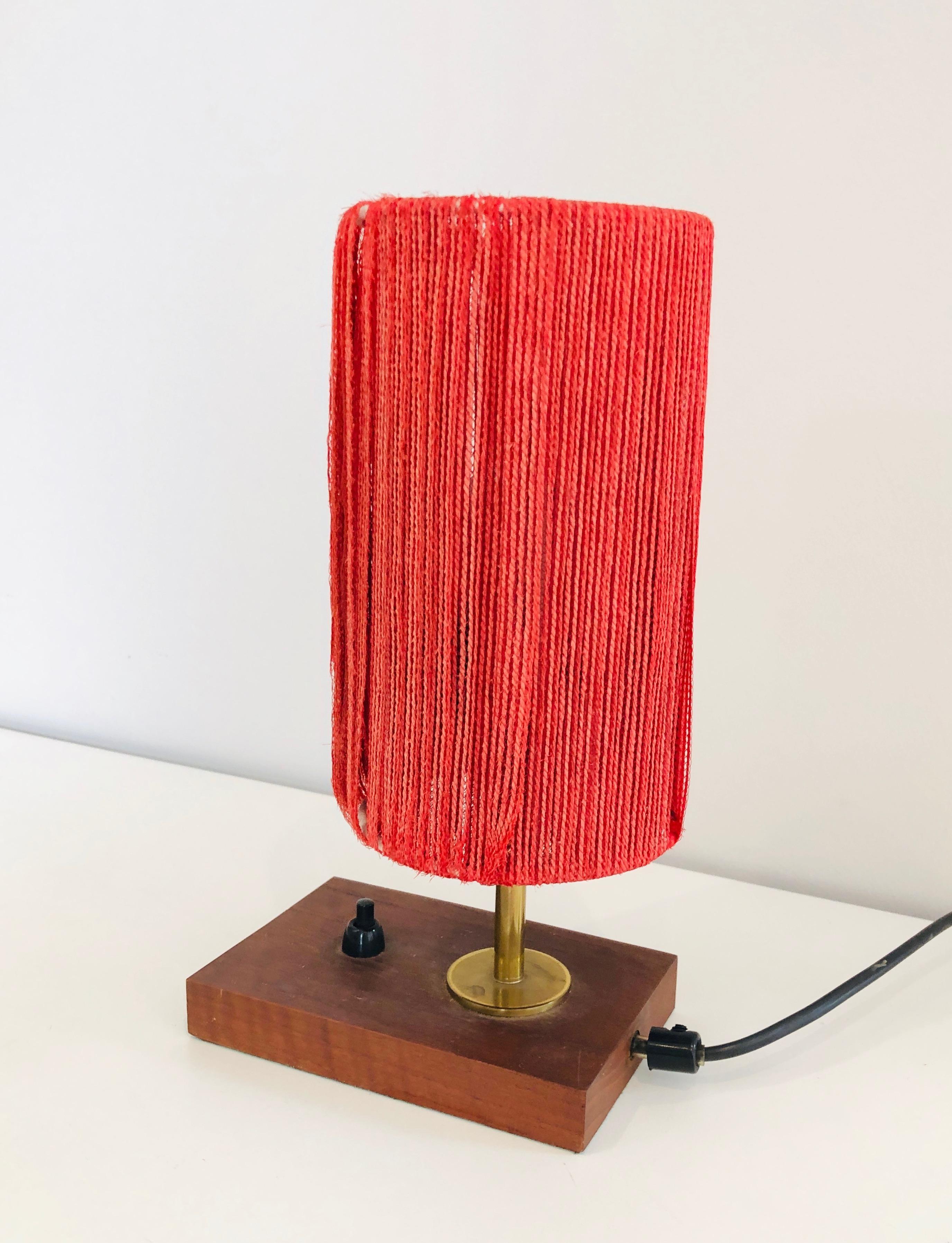 This small table lamp is made of wood, brass with a wool shade. This is a French work. Circa 1950