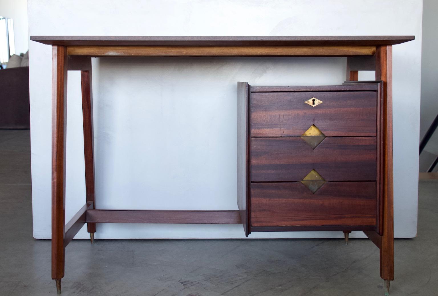 Writing desk made in Italy, circa 1960s. The desk has been partially restored and has a tabletop made of a different, but similar color wood. Brass details and feet that show some age-related wear.