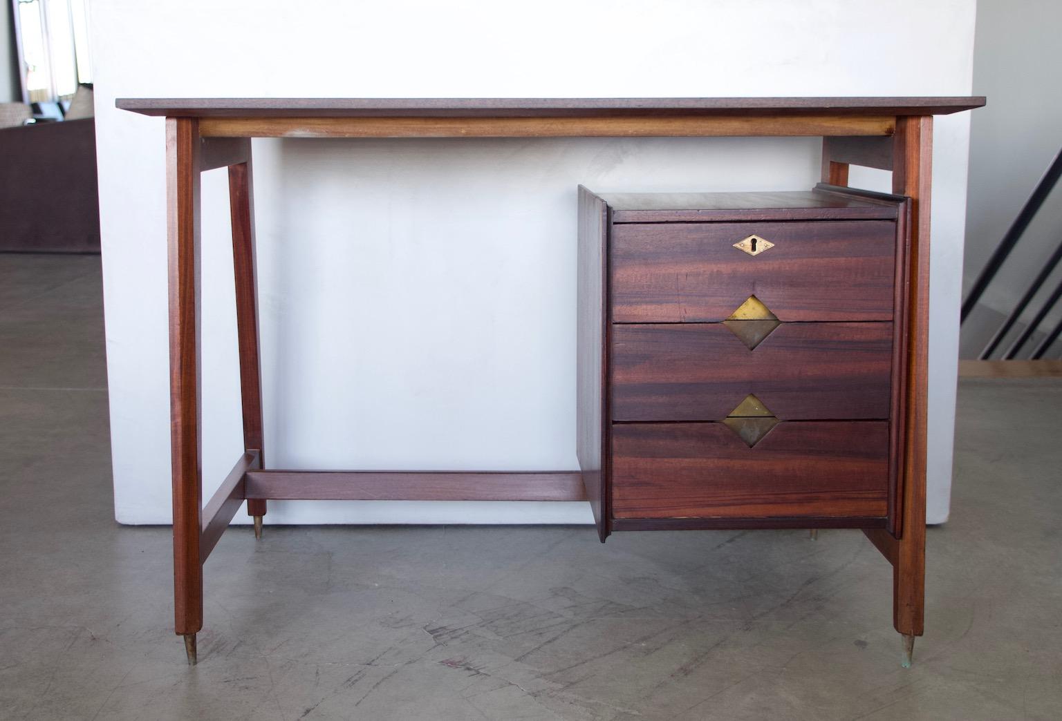 Scrivania moderna di metà secolo in legno di noce con finitura scura e ricca. Realizzato in Italia, intorno agli anni '60. La scrivania è stata parzialmente restaurata e presenta un piano rettangolare in un legno diverso, ma di colore simile. Il