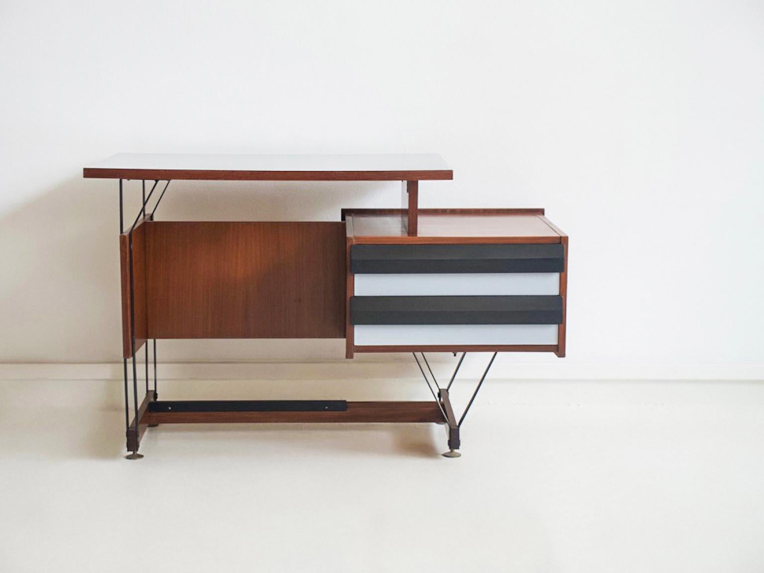 Piccola scrivania in legno e metallo, piano in formica. La parte anteriore dei due cassetti è dipinta in bianco e nero. Prodotto in Italia negli anni '1960. Si prega di notare alcuni segni sulla parte superiore e l'usura della parte inferiore su un