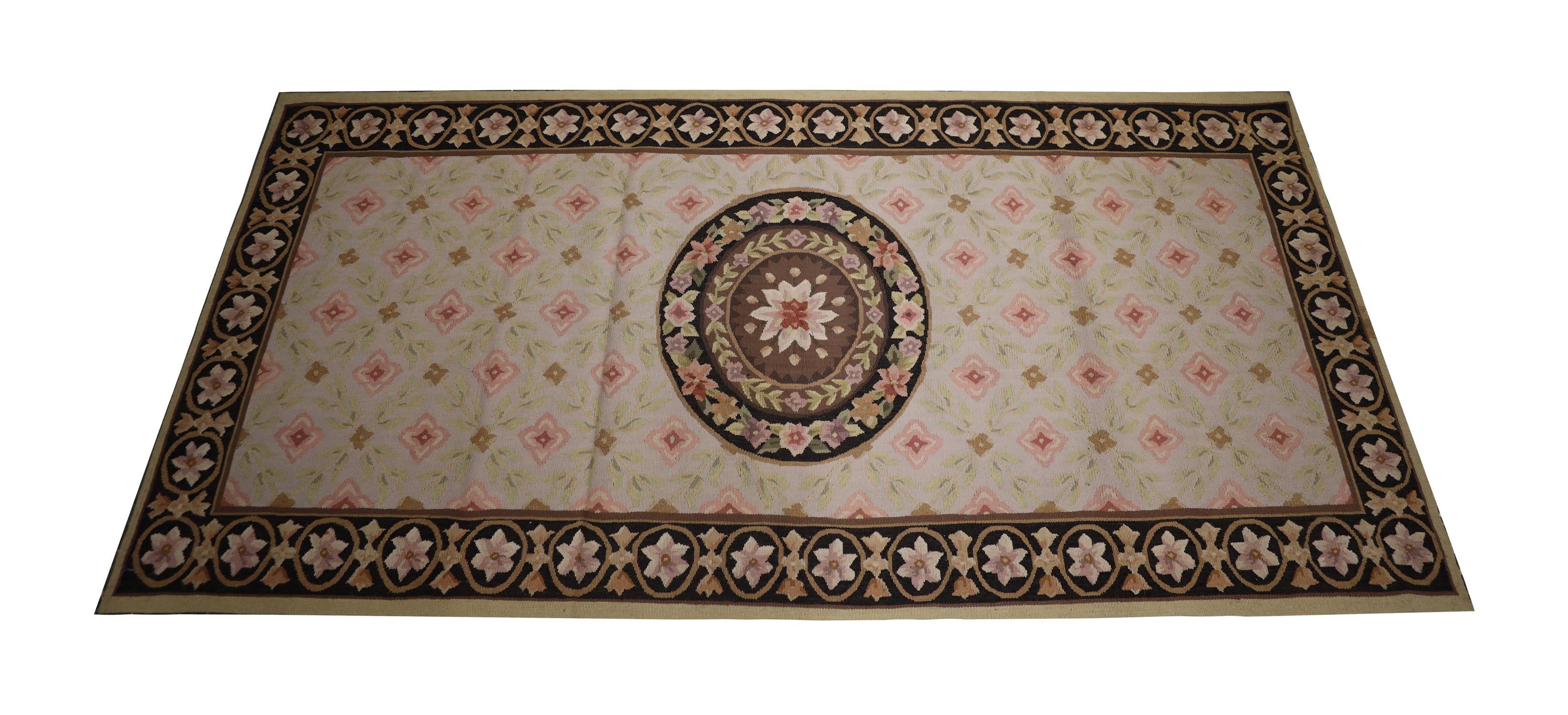 Ce nouveau point d'aiguille en laine est une pièce élégante tissée avec un motif floral asymétrique tissé avec un beau médaillon floral circulaire sur un fond de motif répétitif. Une bordure en gras encadre ensuite le tout. Le design traditionnel et